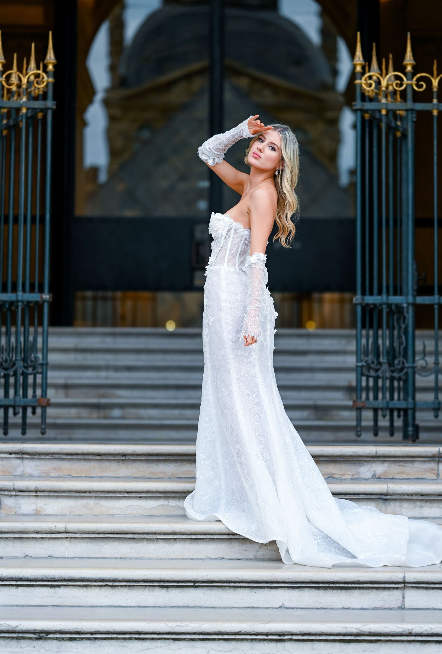 Dramatic bridal poses on grand stone steps with ornate gold railings.