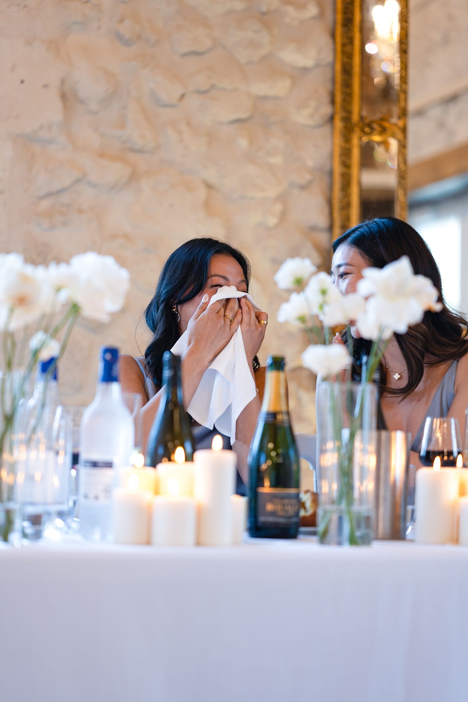 Emotional moment captured at wedding reception with candles and floral centerpieces.