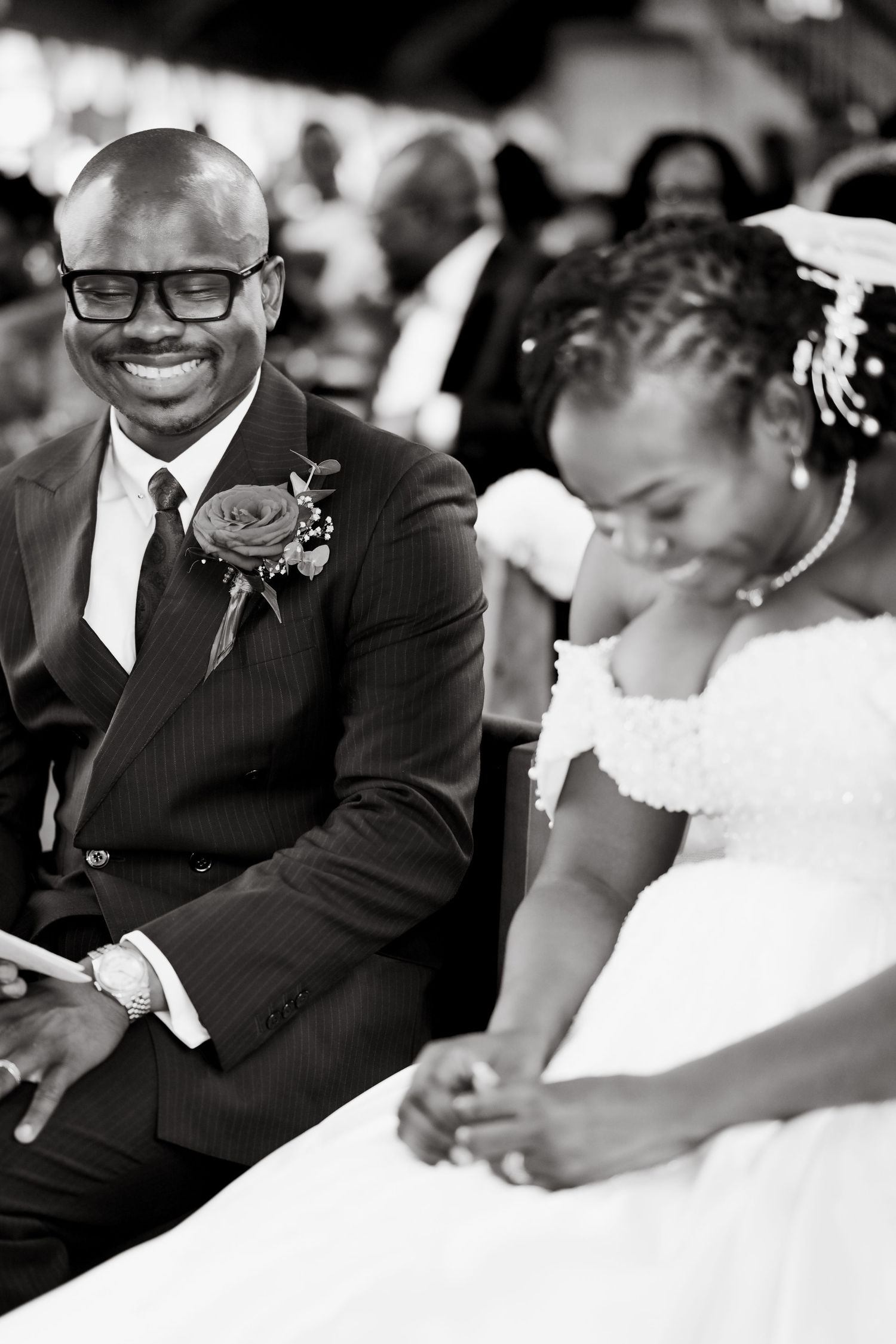 Black and white candid wedding reception photos showing joyful moments between guests in formal attire.