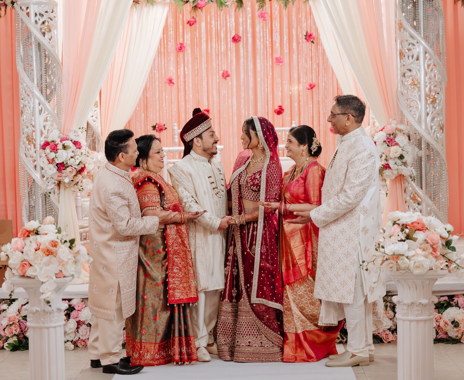 A panoramic view of a traditional Indian wedding ceremony with ornate decor and white and red color scheme.