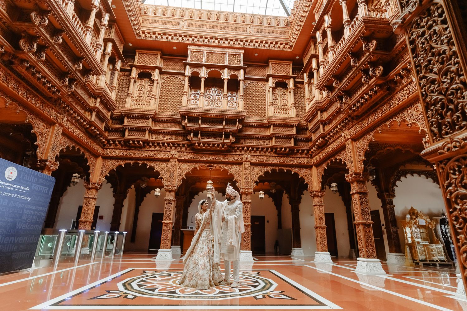 Stunning architectural details of an ornate temple interior with carved wooden pillars and decorative ceiling.