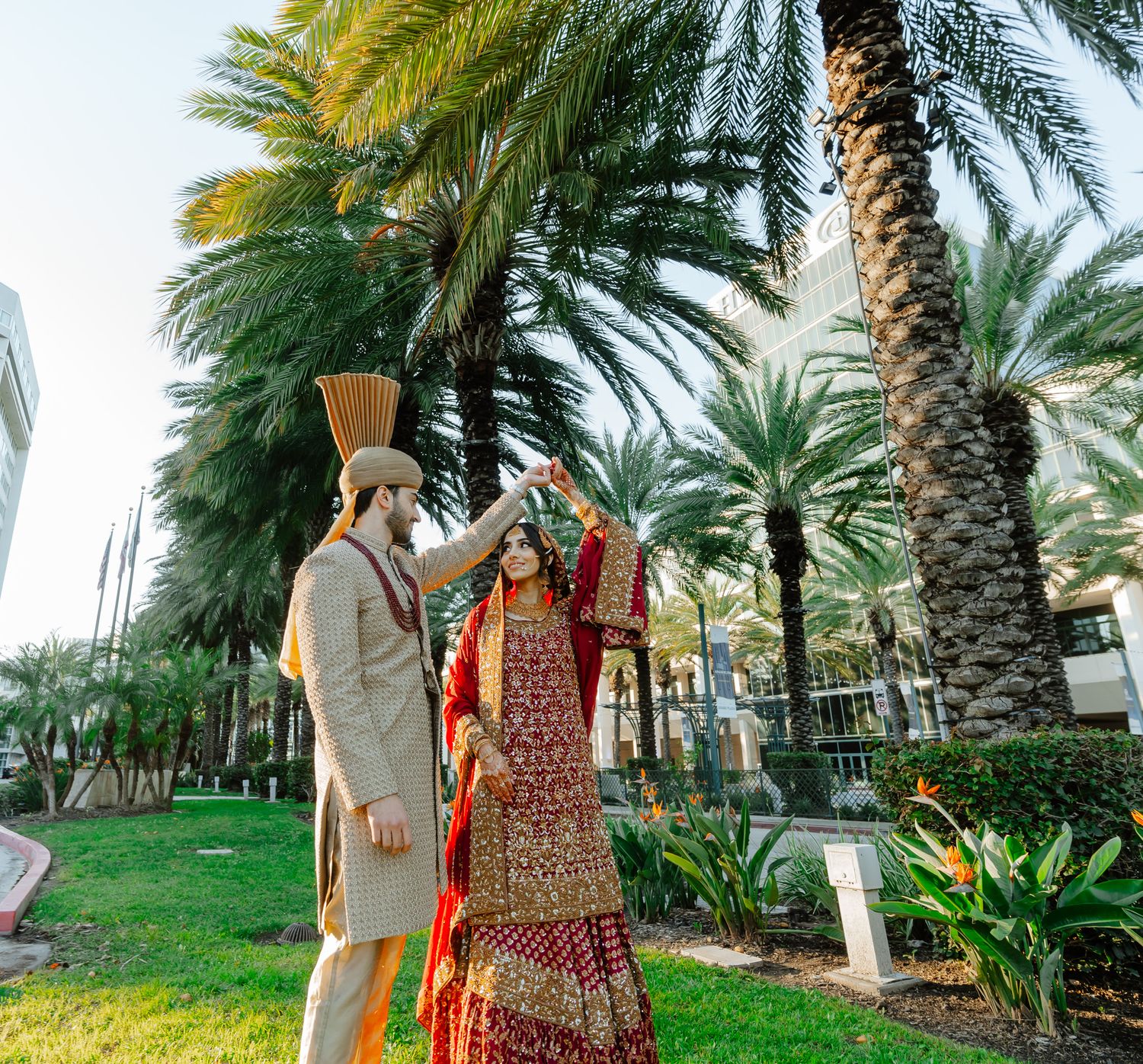 A scenic palm tree-lined pathway with people celebrating during golden hour.