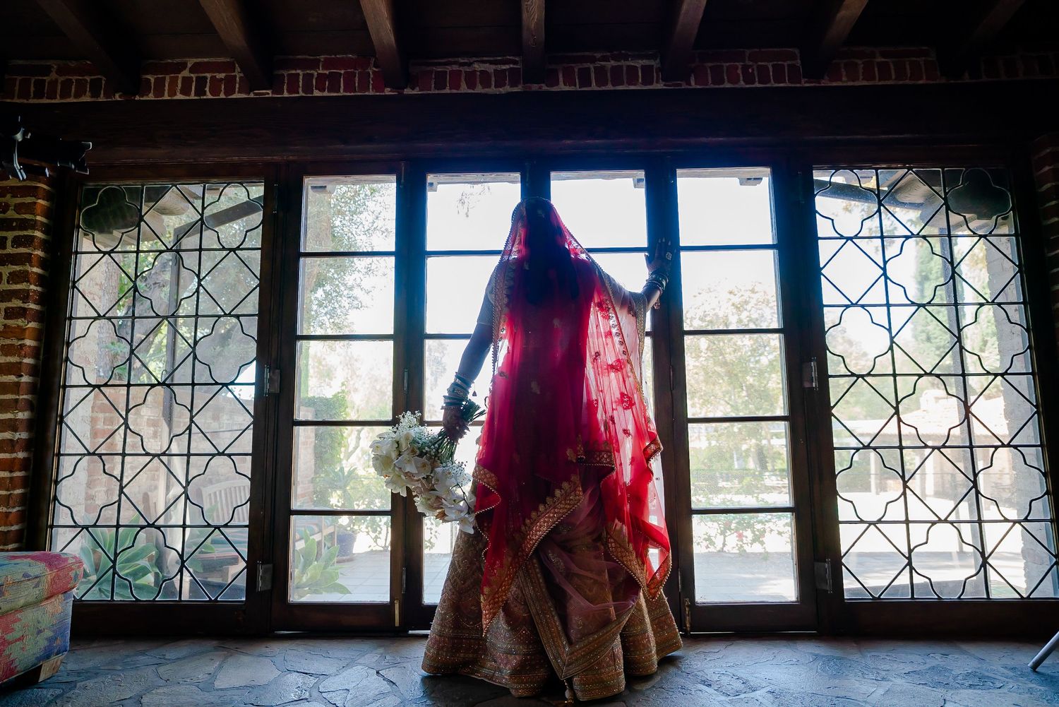 Ornate window frames with decorative patterns create an architectural backdrop in an indoor setting.