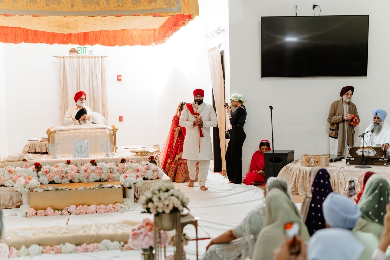 Elegant wedding reception setup with white tablecloths and rustic decor in a bright indoor venue.