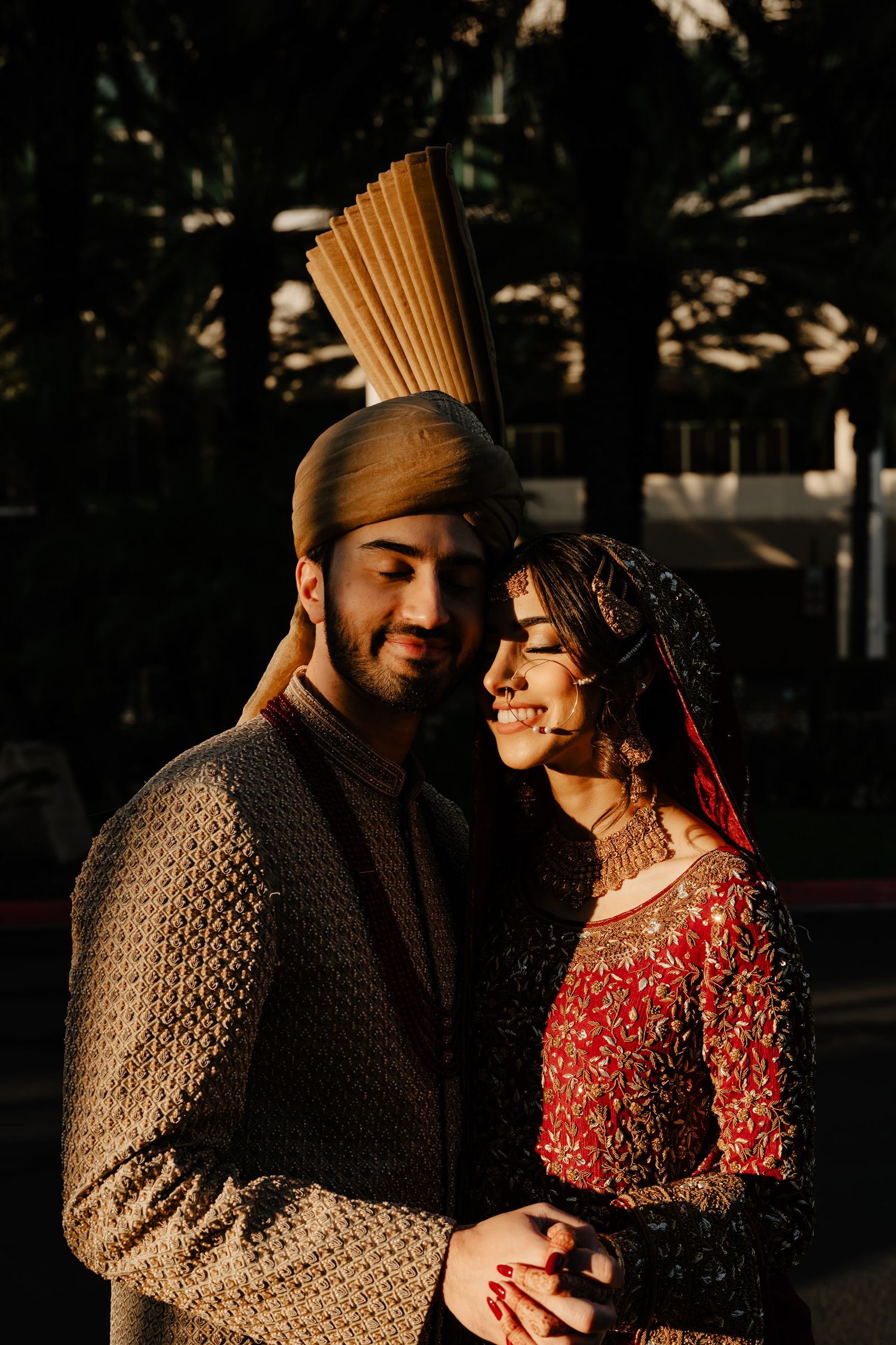 Romantic sunset portrait of couple in traditional South Asian wedding attire.