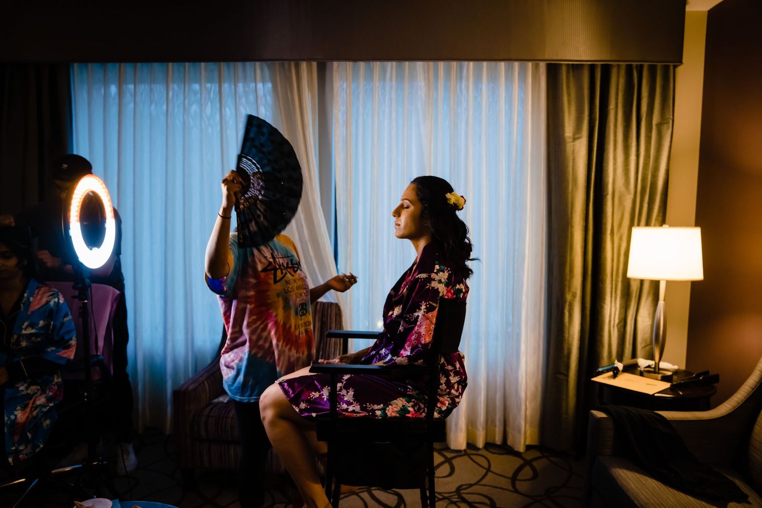 A cinematic sequence showing silhouettes of people in a dimly lit hotel room with window light.