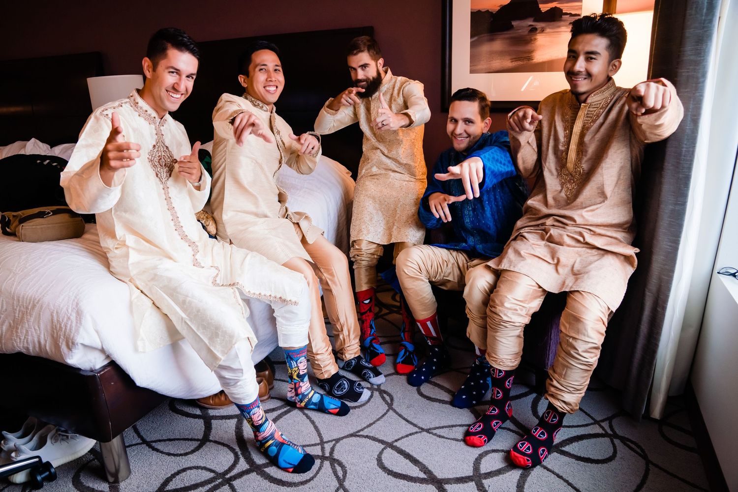 A group of people in light colored outfits sit on chairs in a row while putting on shoes.