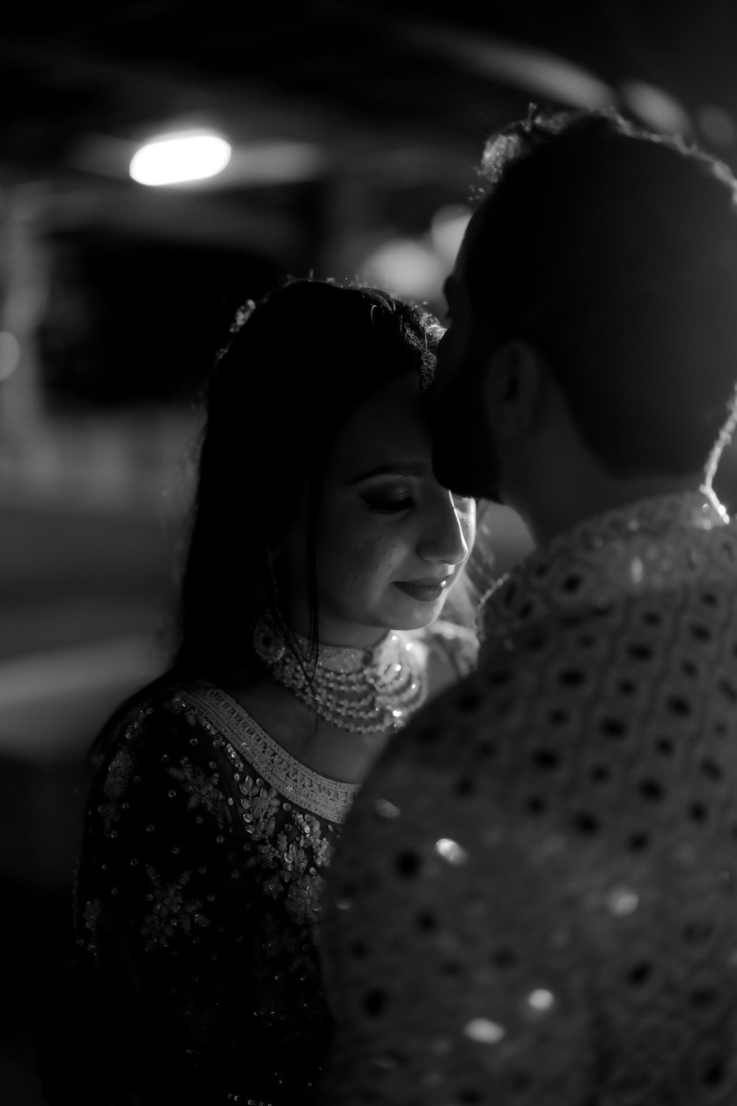 A black and white artistic portrait series showing intimate moments between a couple in traditional attire.
