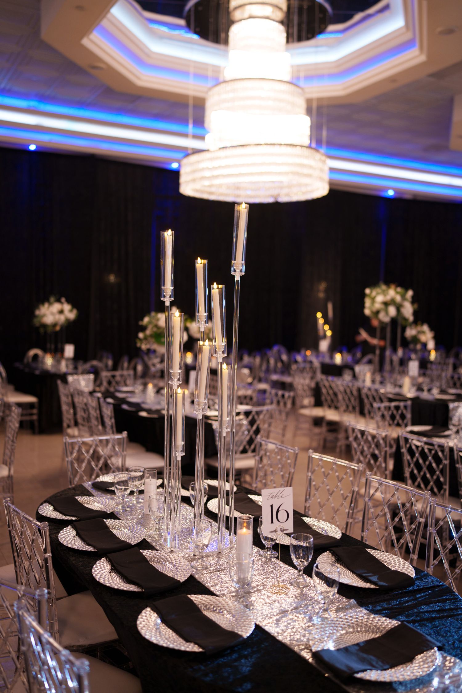 Elegant table setting with crystal candle holders and black place settings at a formal reception.