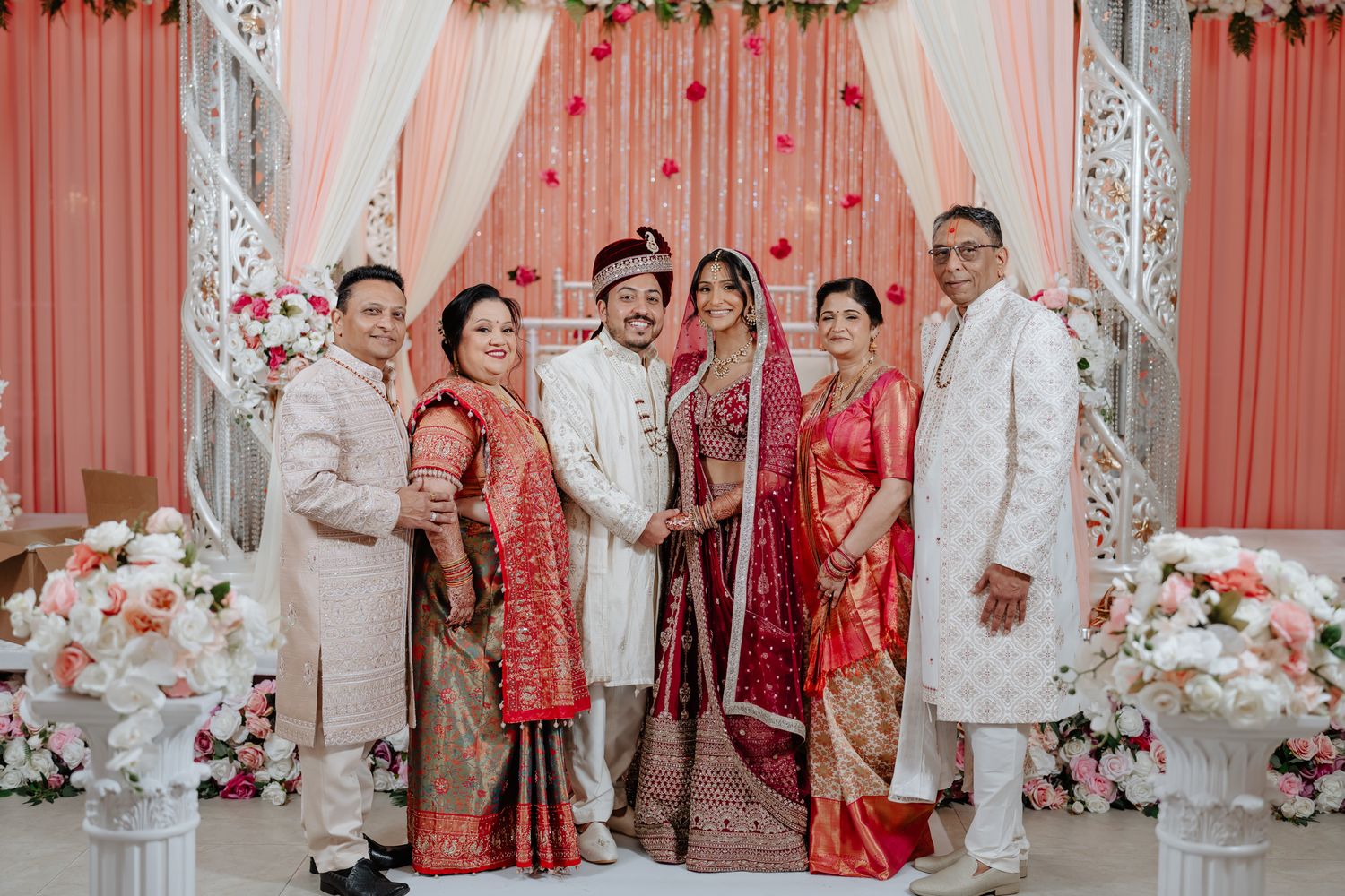 Elegant South Asian wedding ceremony setup with pink and white draping, floral decor, and traditional elements.