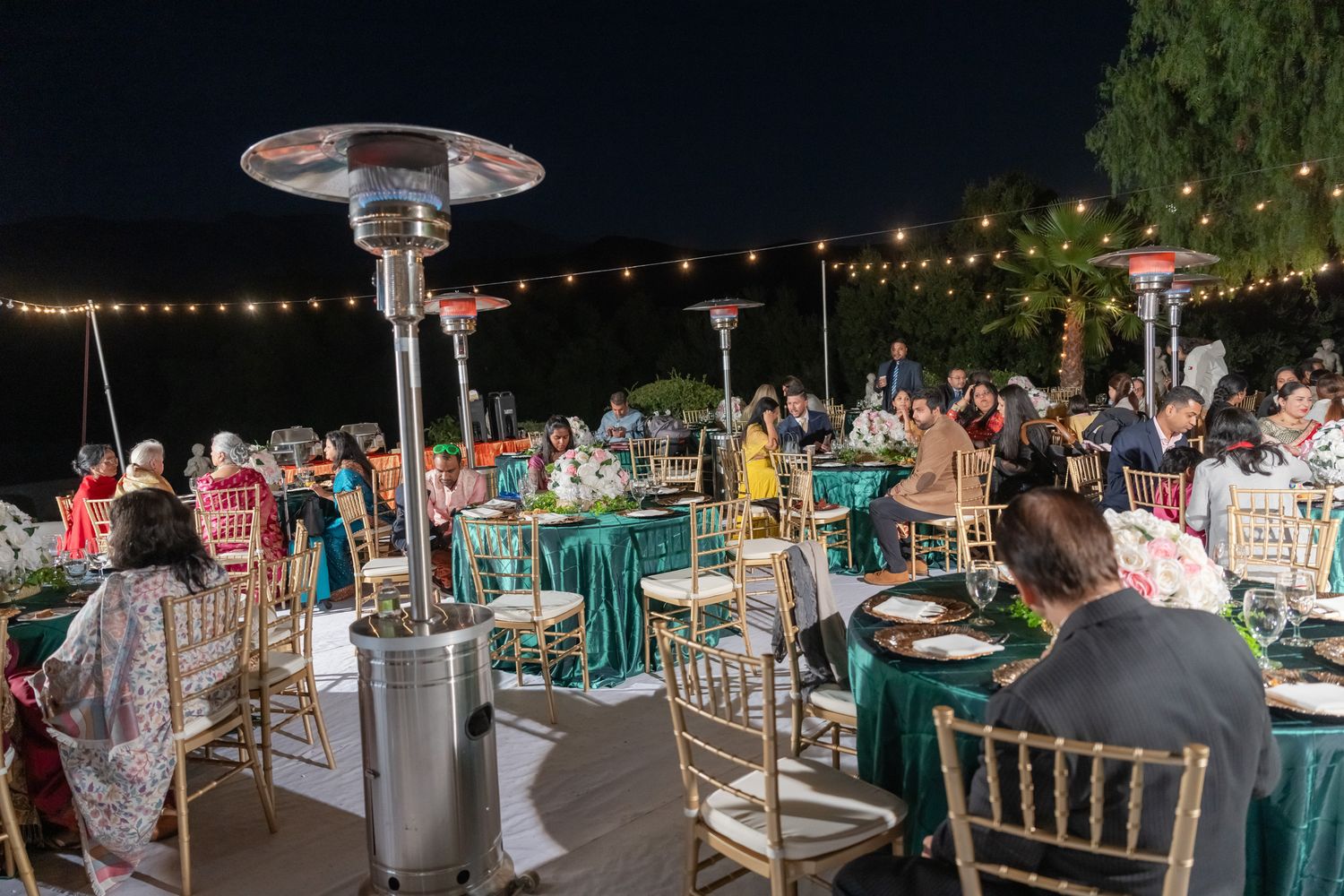 Nighttime wedding reception with string lights and elegant table settings.