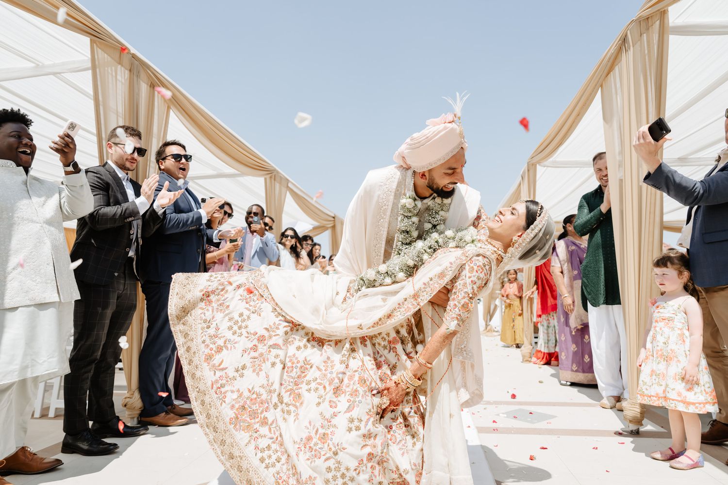 A series of outdoor wedding ceremony photos showing a flowing white dress and guests in attendance.