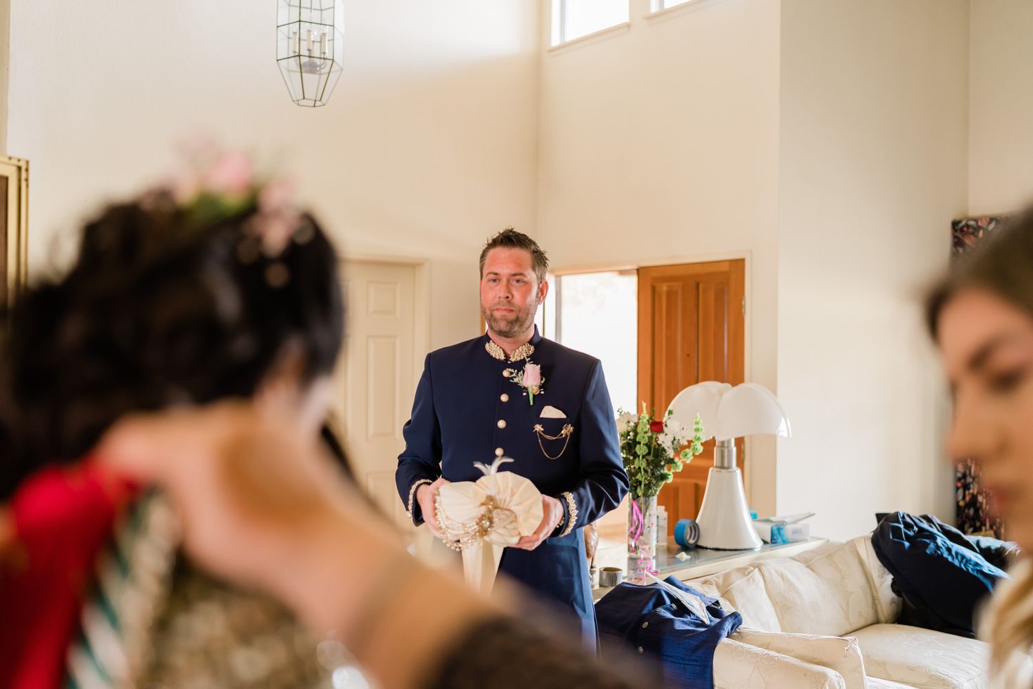 Wedding guests and participants gather in a bright, sunlit room during a celebration.
