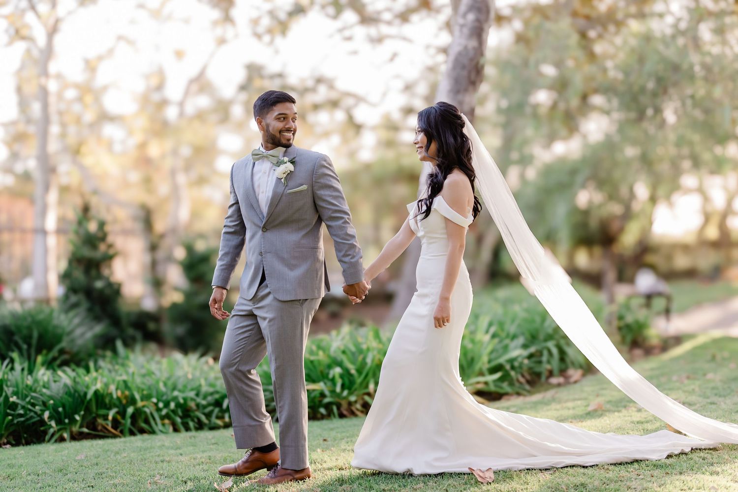 Romantic wedding photography session in a garden setting with flowing white veil.