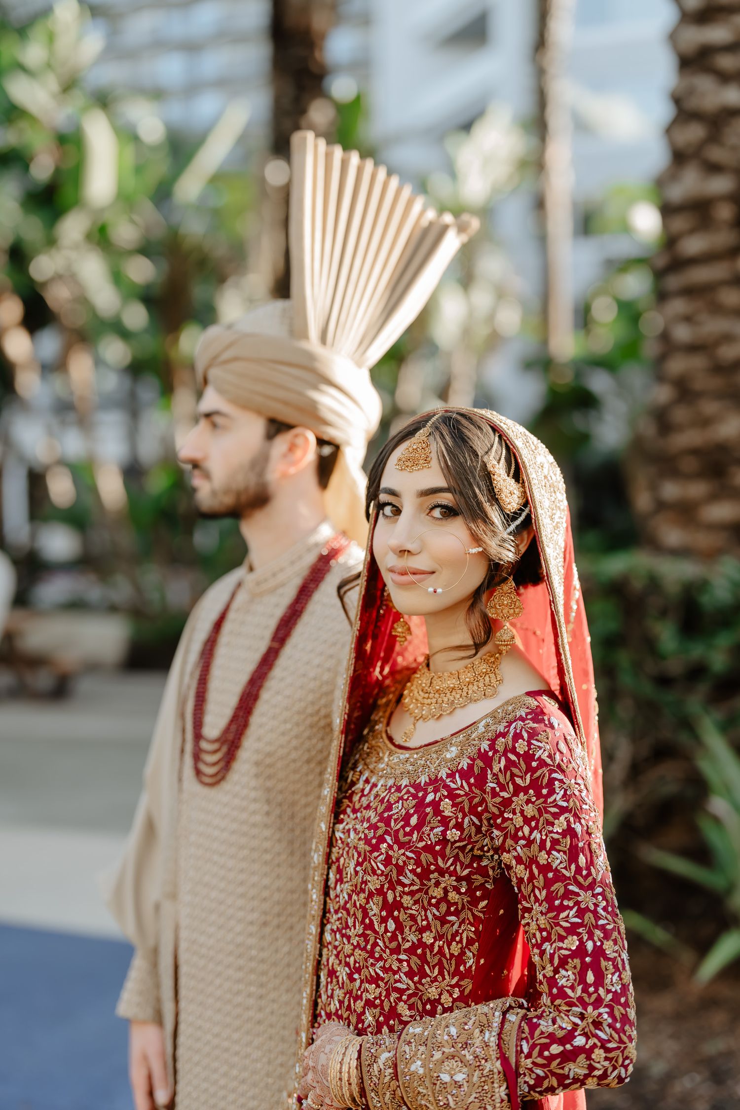 Outdoor wedding portraits with palm trees and natural lighting.