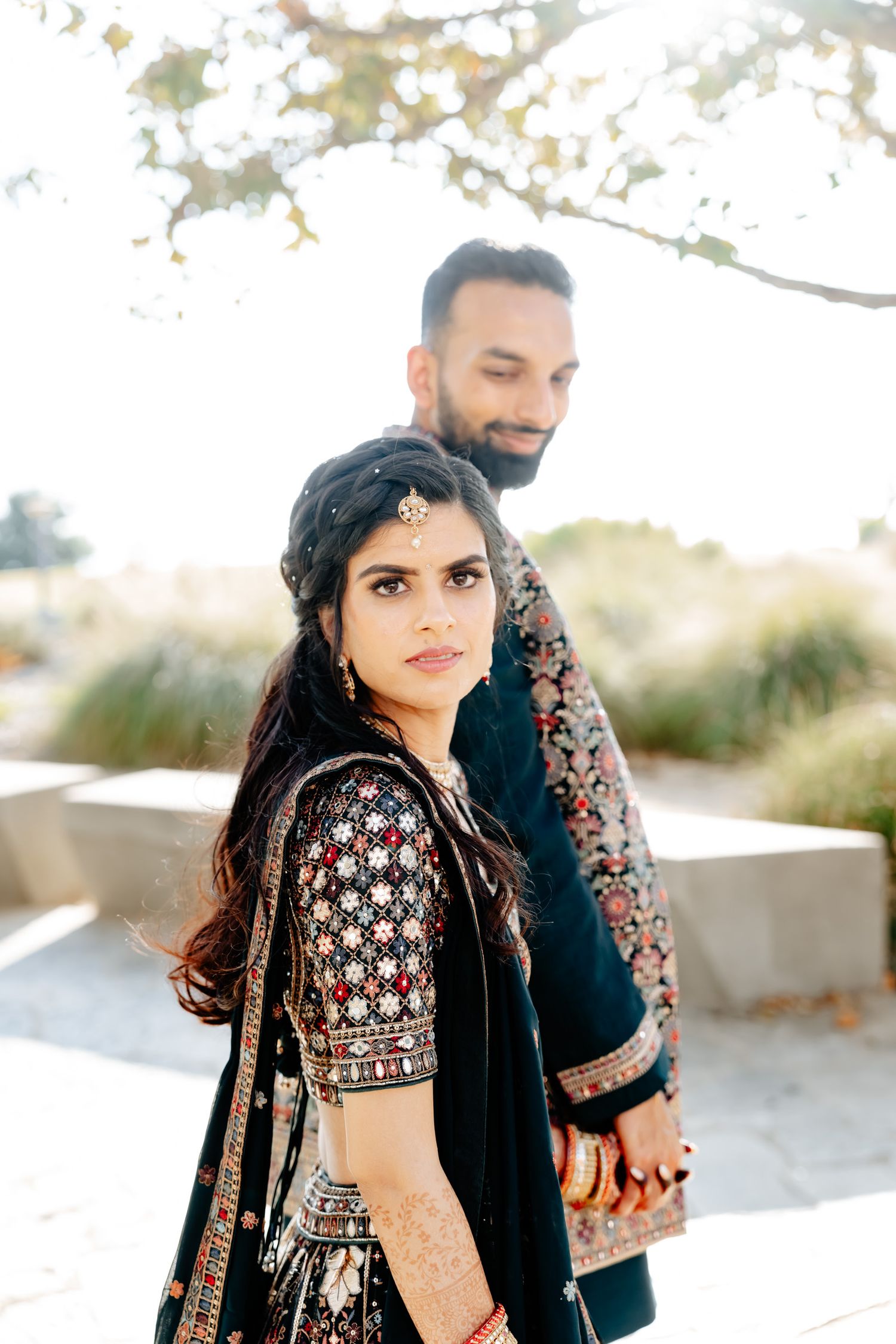 Artistic wedding photography with traditional Indian bridal attire against white background.