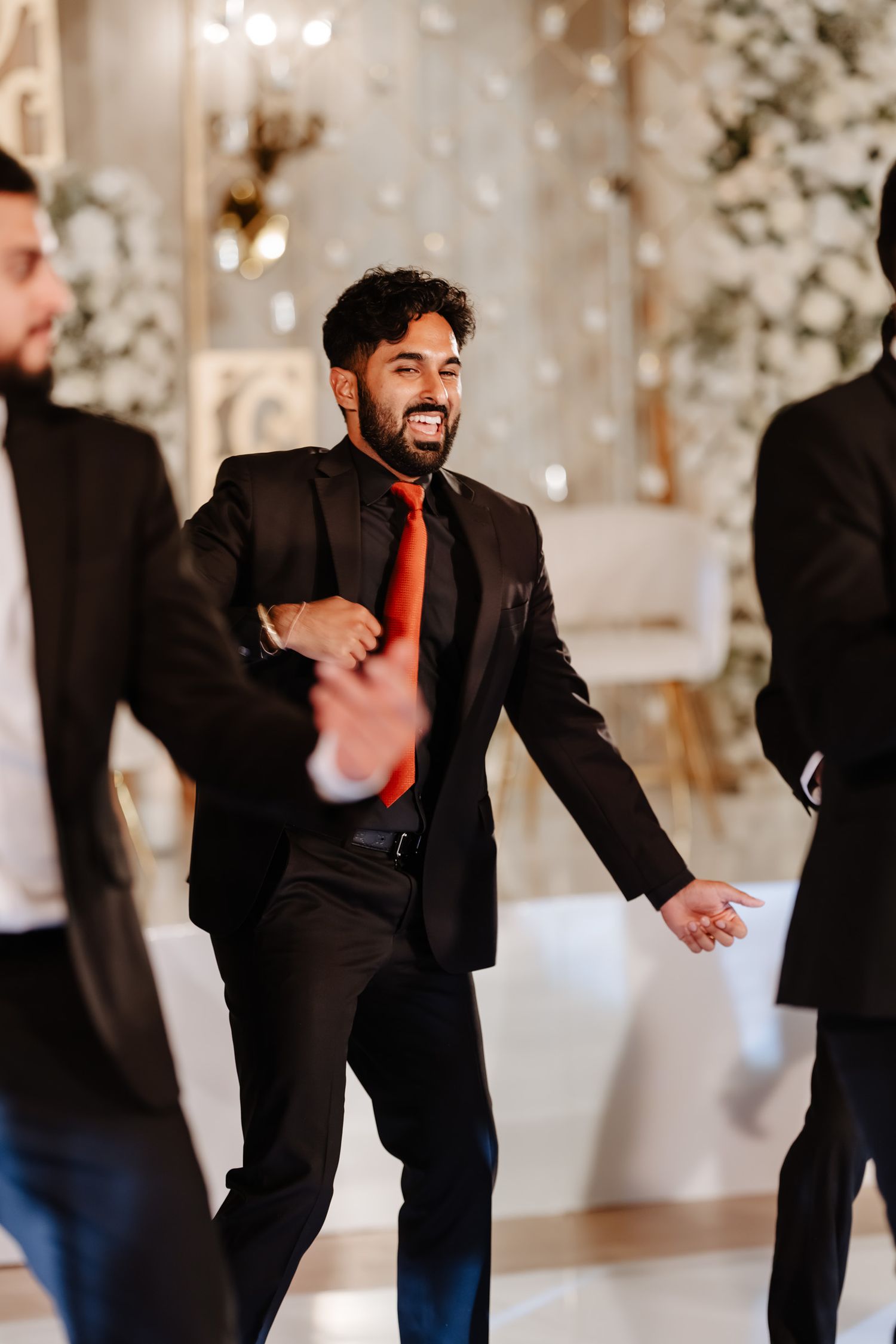 A sequence of candid dance floor moments showing people celebrating at an elegant indoor venue with white decor.