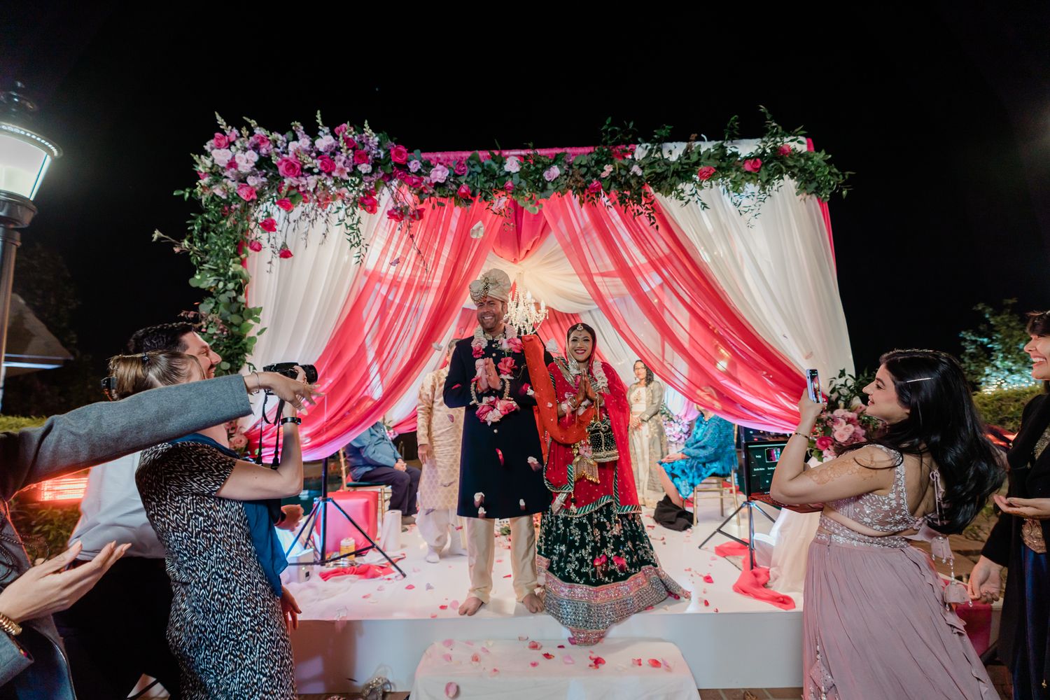 Panoramic view of a wedding reception venue decorated with pink drapes and floral arrangements.