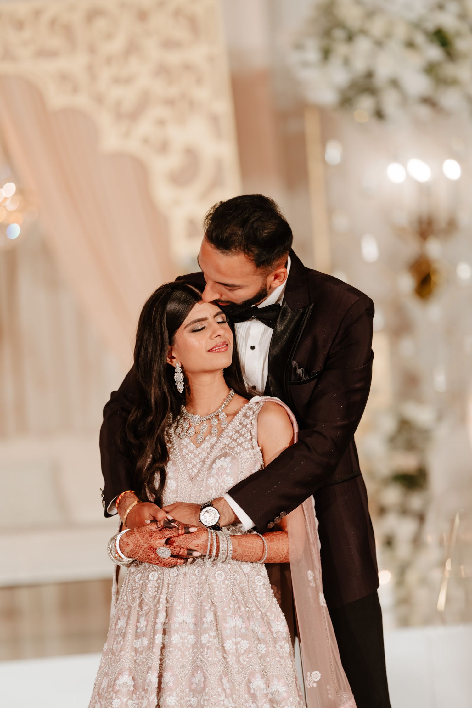 Intimate moment captured during wedding reception with elegant decor and soft lighting.
