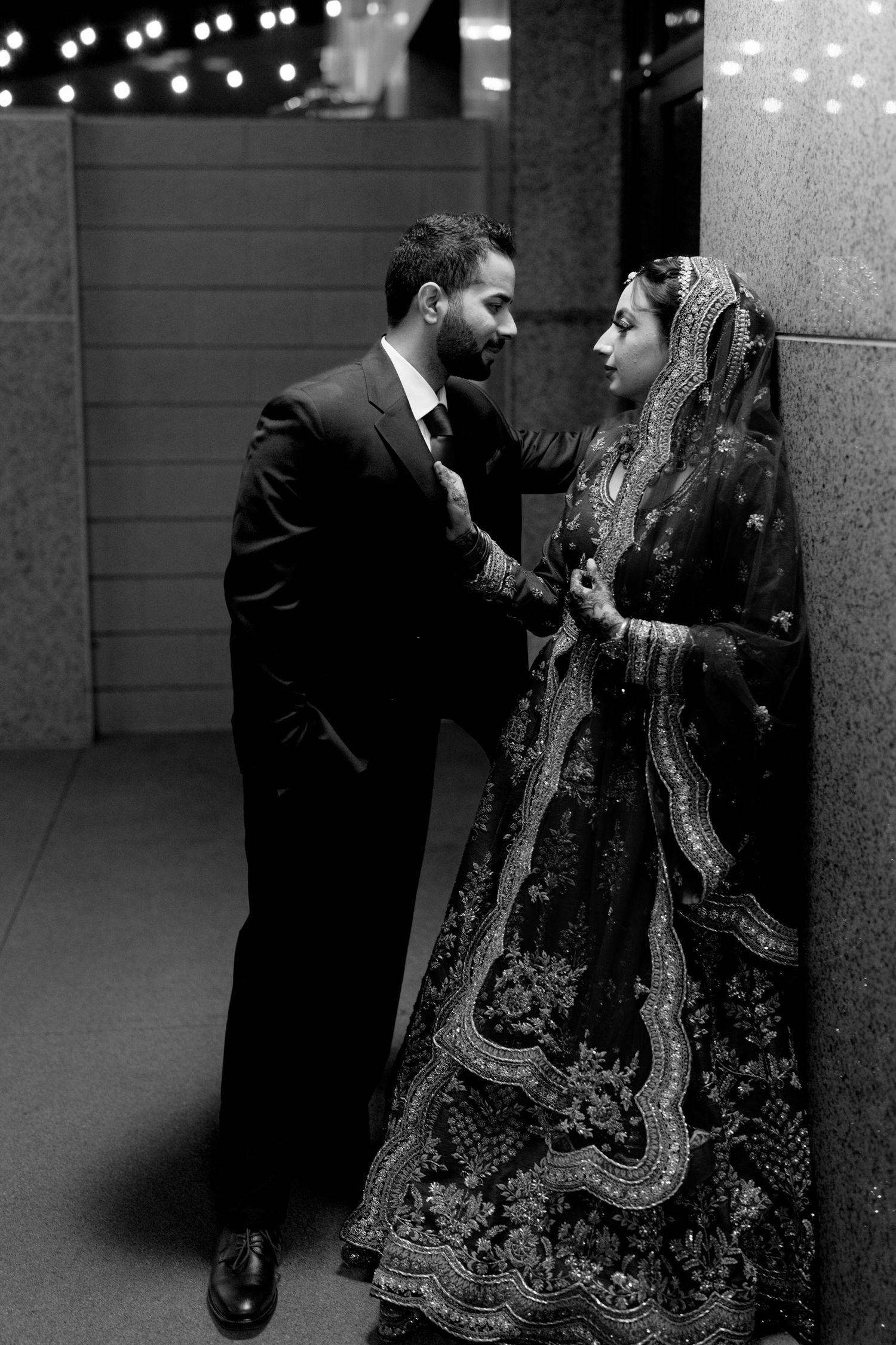 Black and white photo series showing a couple in traditional South Asian wedding attire dancing together.