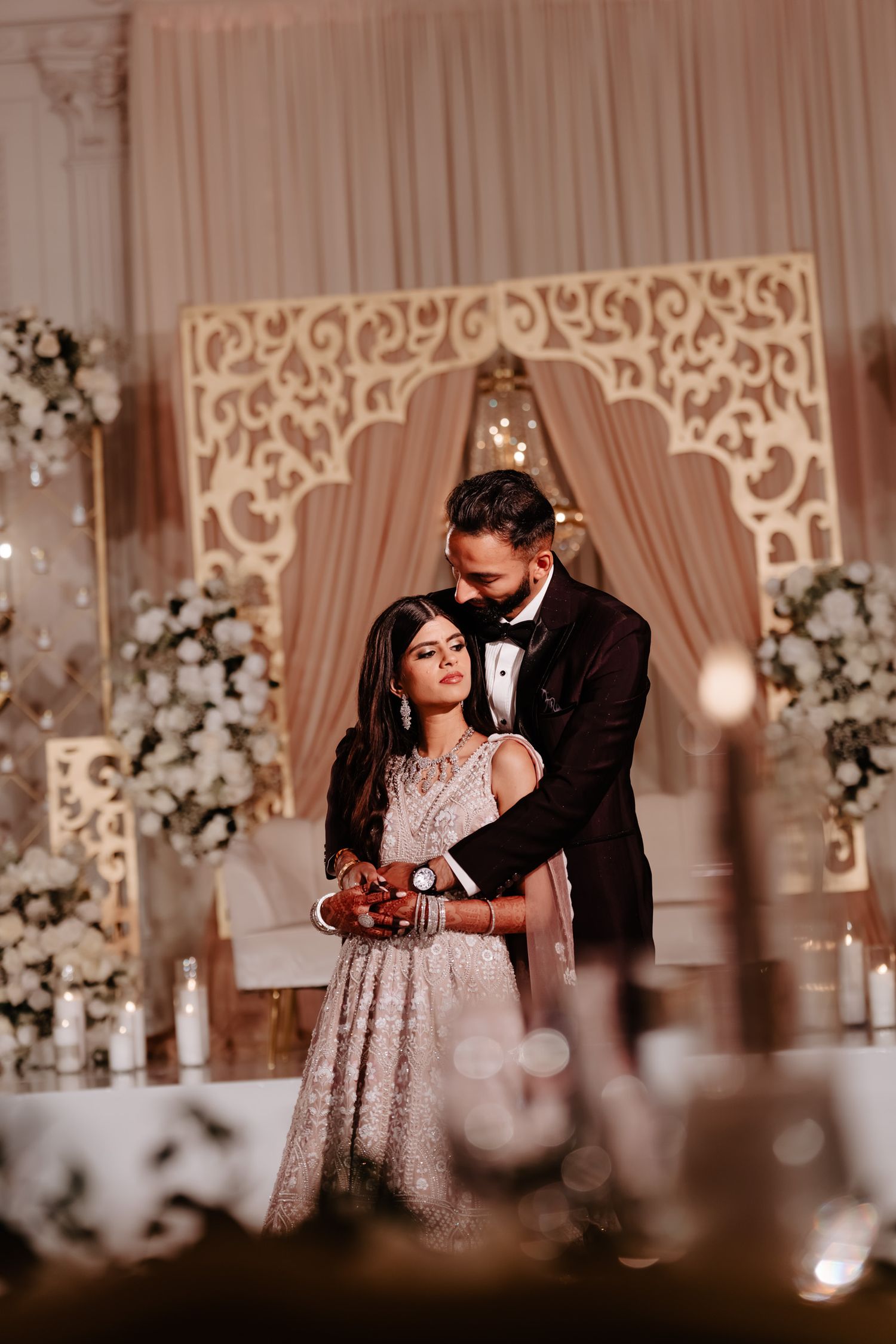 Romantic dance scene at a wedding reception with elegant decor and floral arrangements.