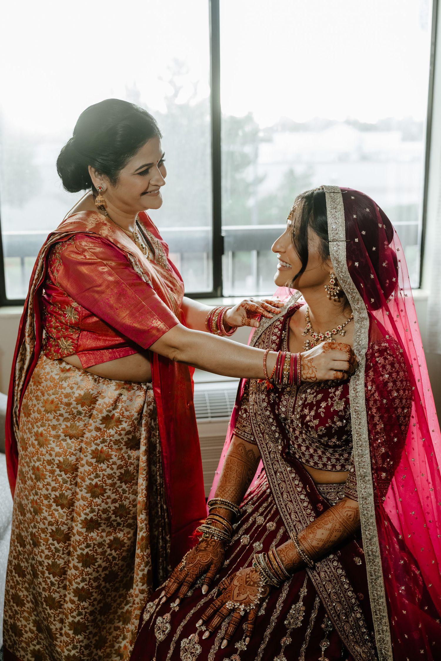 Getting ready scene showing traditional South Asian wedding preparations in a bright room.