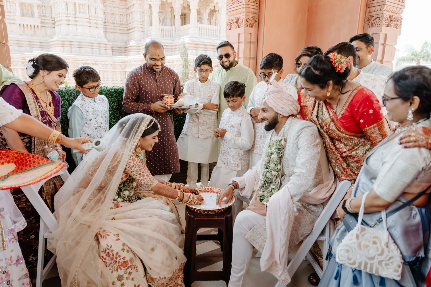Wedding guests celebrating with white attire and traditional decorations at an Indian ceremony.
