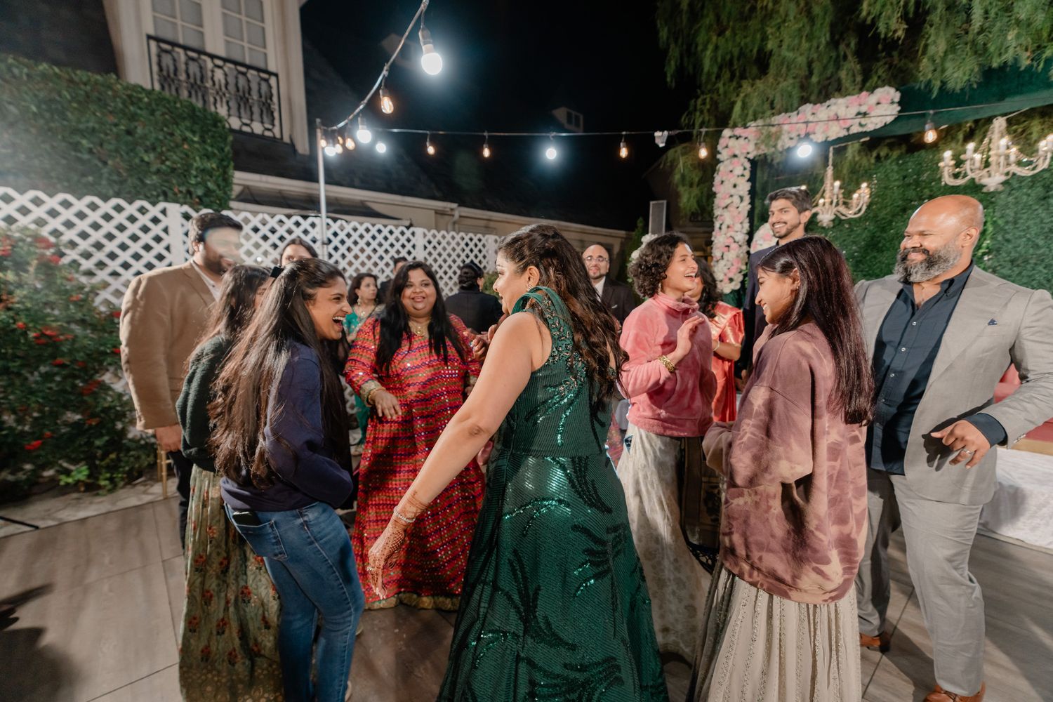 Outdoor wedding reception with string lights and lattice decorations.