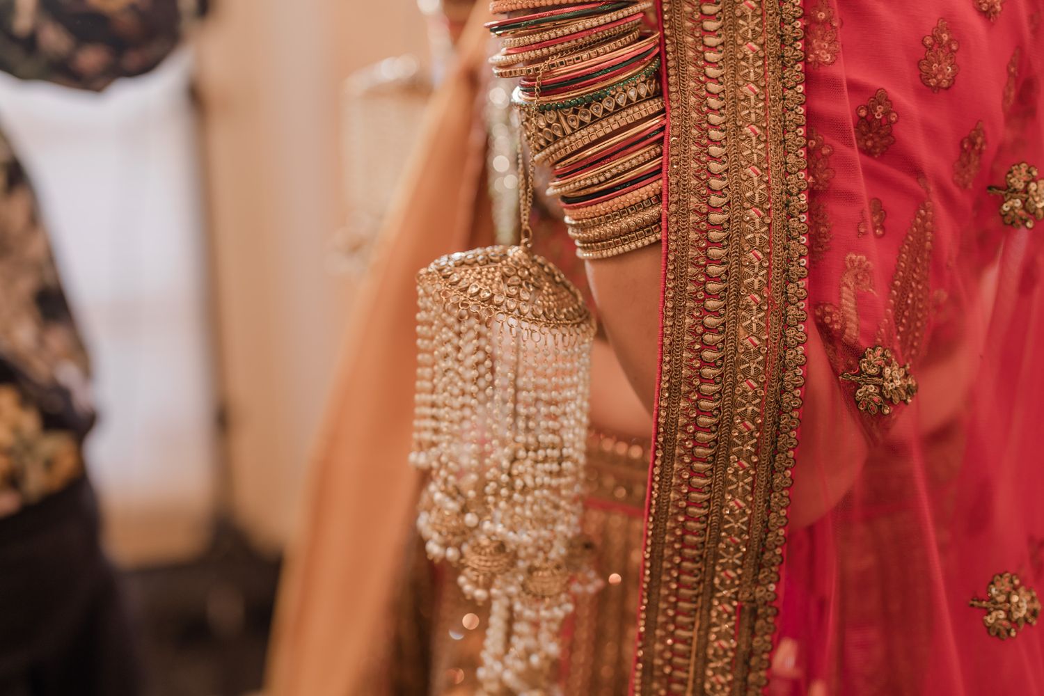 A close-up view of traditional Indian bridal jewelry featuring intricate gold details and pearl embellishments.