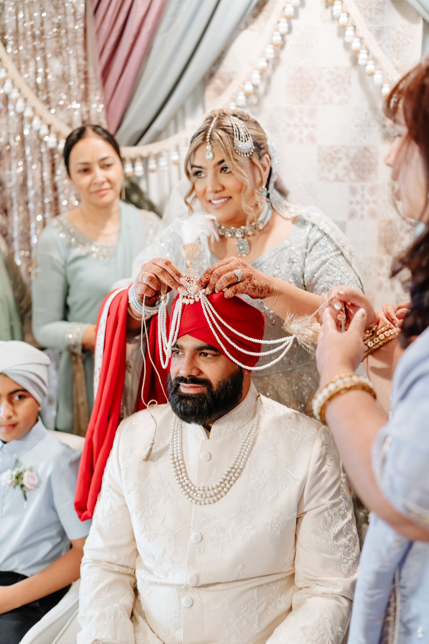 Traditional Indian wedding ceremony showing pearl necklace being placed during ritual celebration.