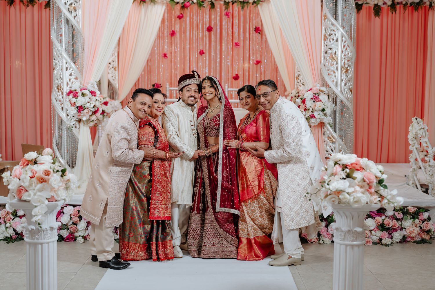 Traditional Indian wedding ceremony setup with pink and white decor featuring floral arrangements and elegant draping.