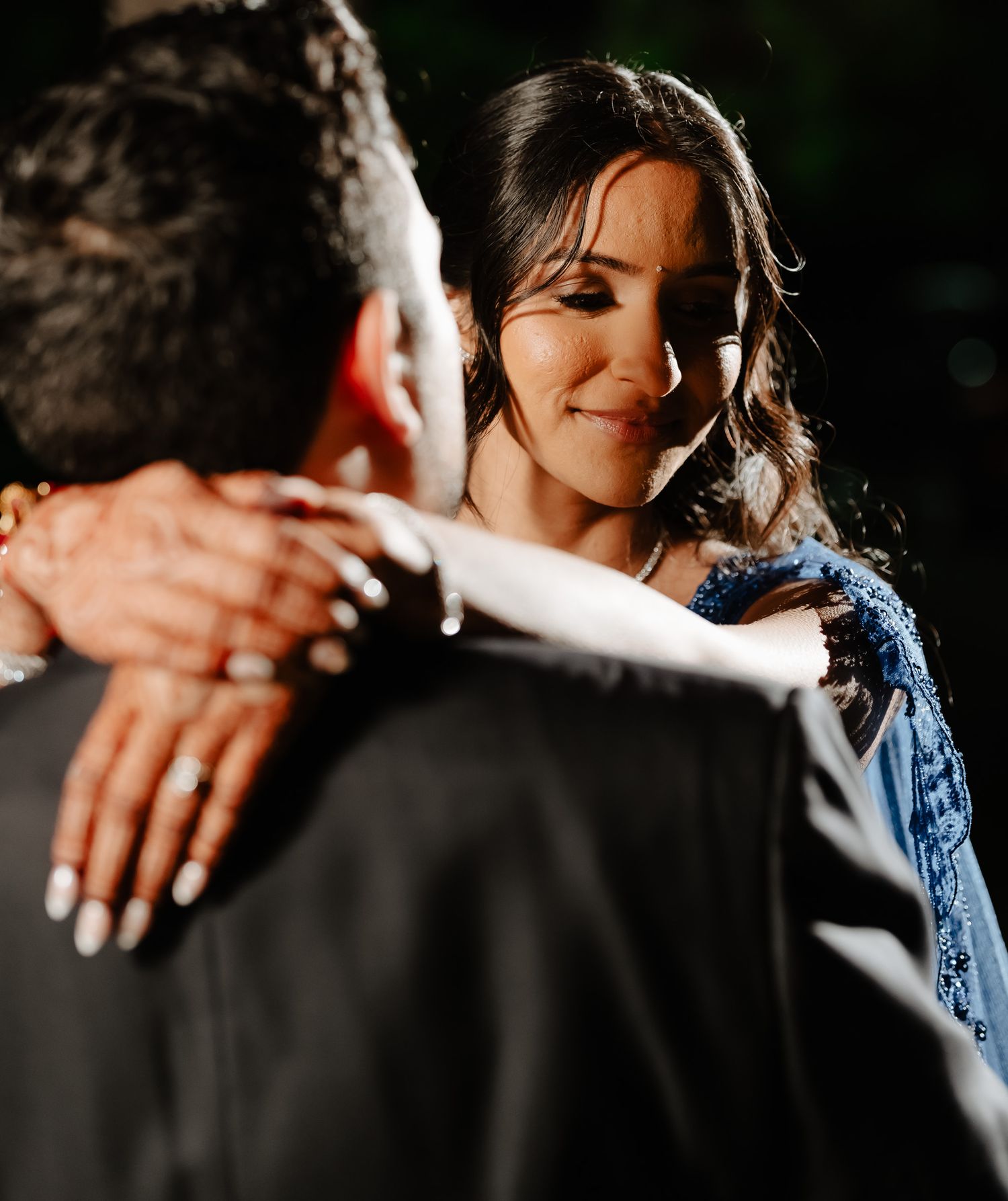 Close-up shot of hands embracing during an intimate dance moment.
