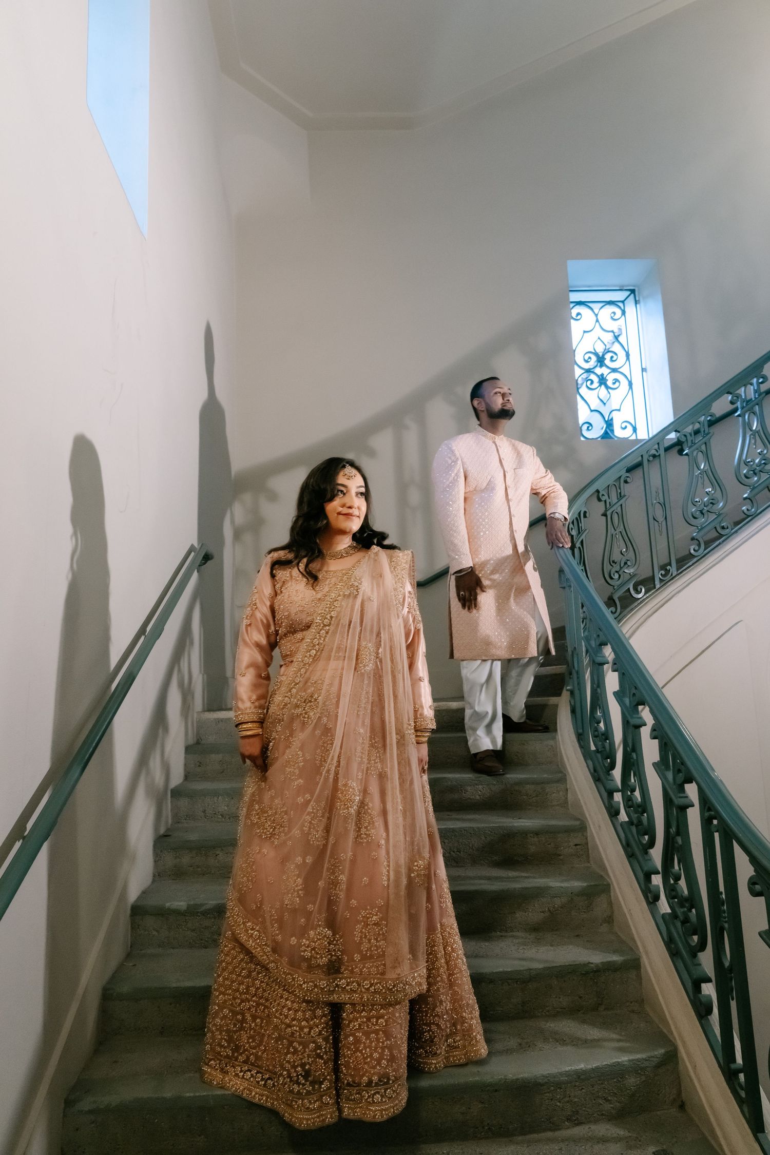 A figure in an elegant beige embroidered dress poses on a staircase with ornate railings in multiple artistic shots.