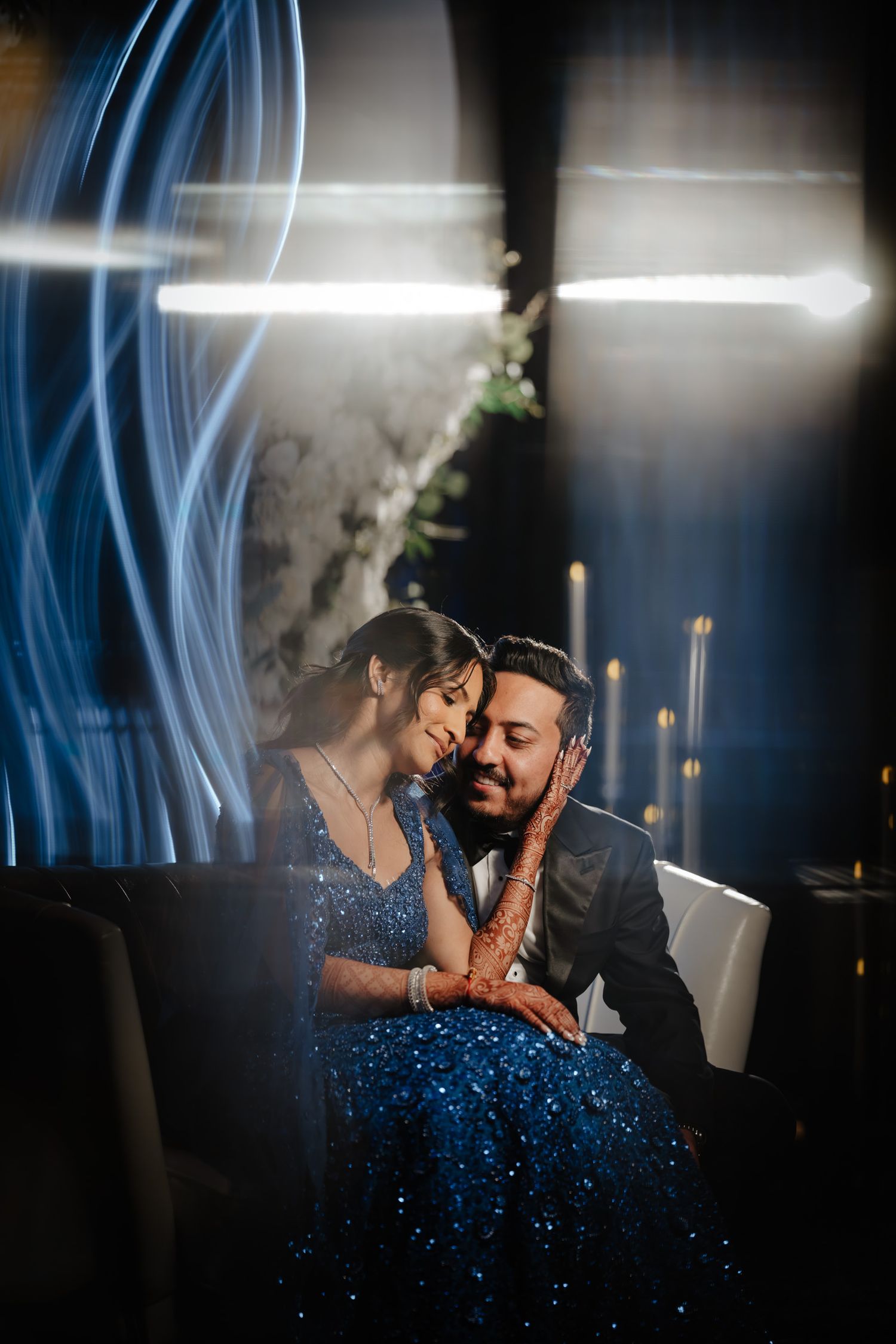 Romantic evening photoshoot with blue lighting and smoke effects creating a dreamy atmosphere.