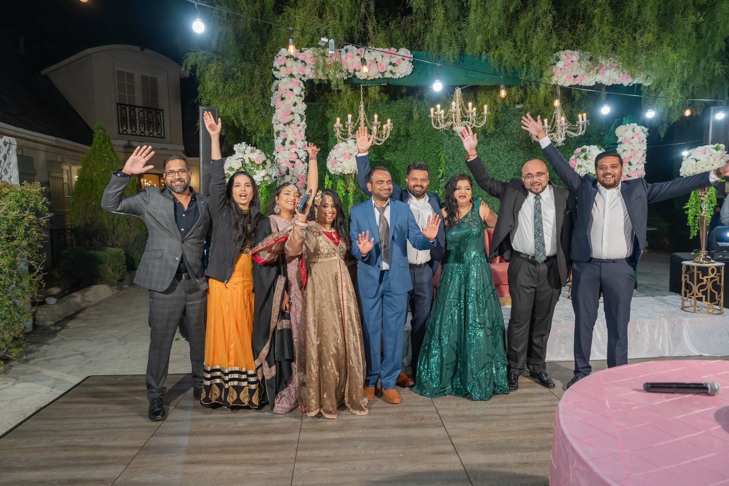 Large group photo of event attendees gathered outdoors under evening lighting.