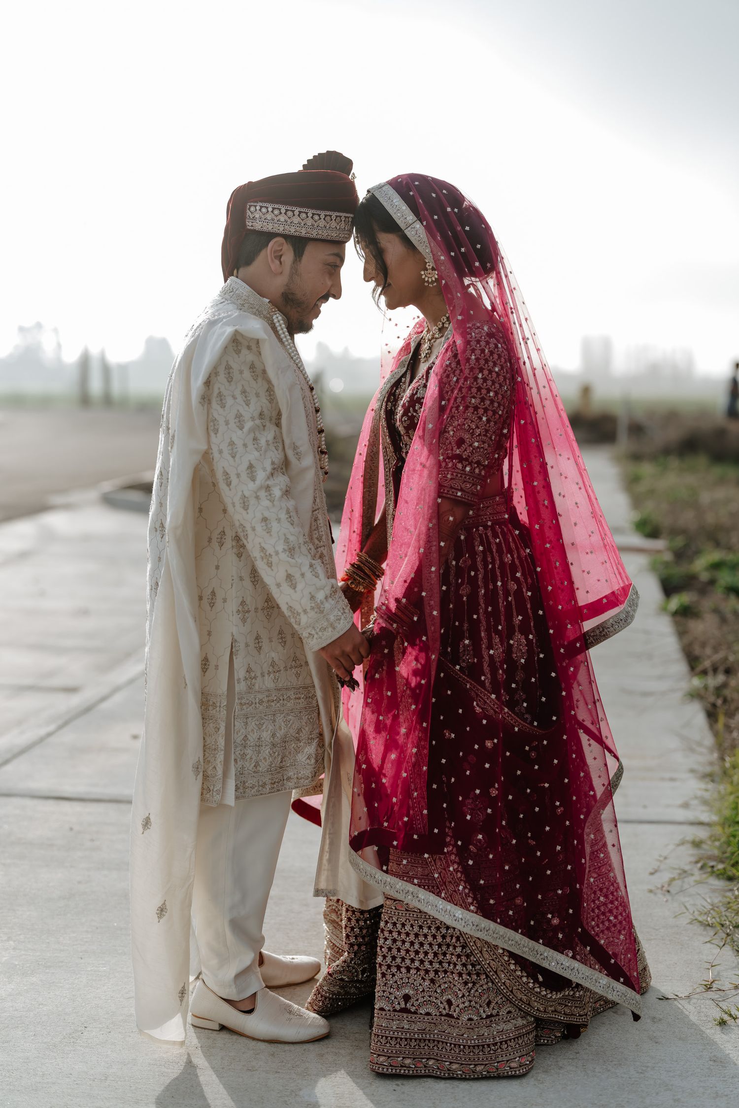 Romantic wedding portraits showing traditional South Asian bride and groom in outdoor setting.