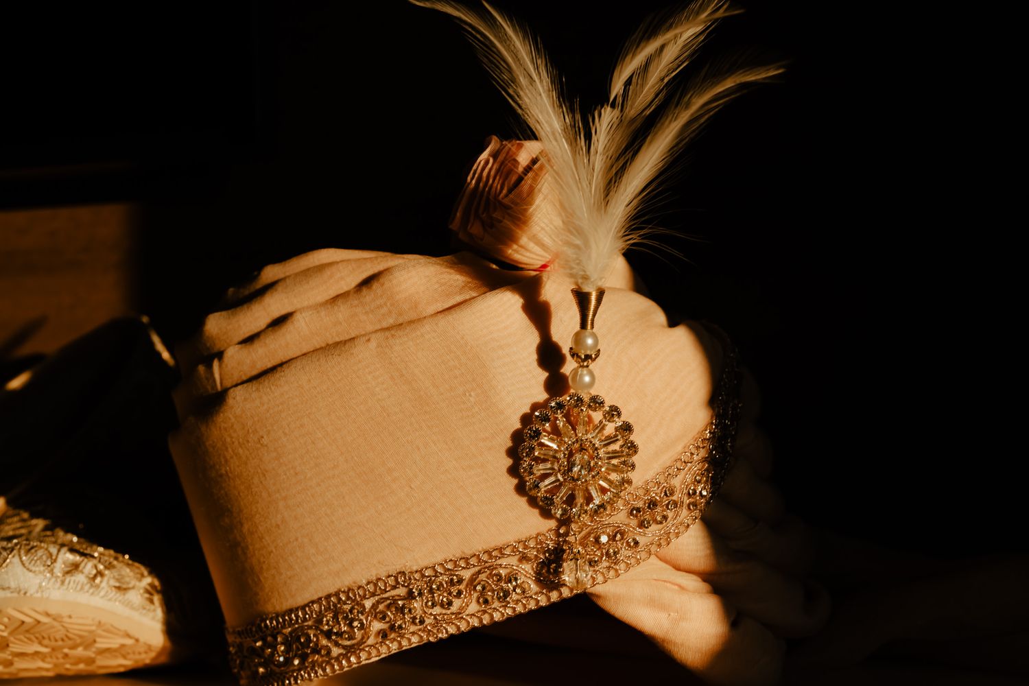 Ornate gold jewelry and traditional wedding accessories displayed on cream colored surfaces.