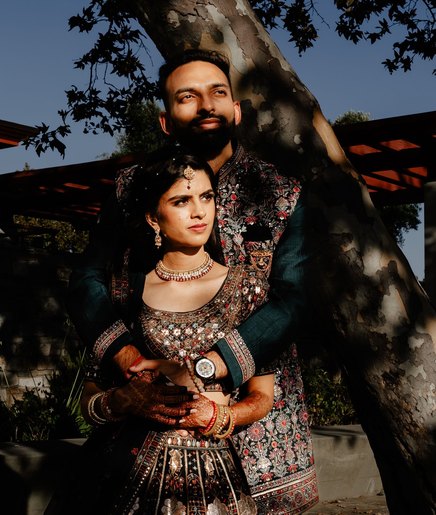 Traditional Indian wedding attire photographed in dramatic outdoor lighting with trees.