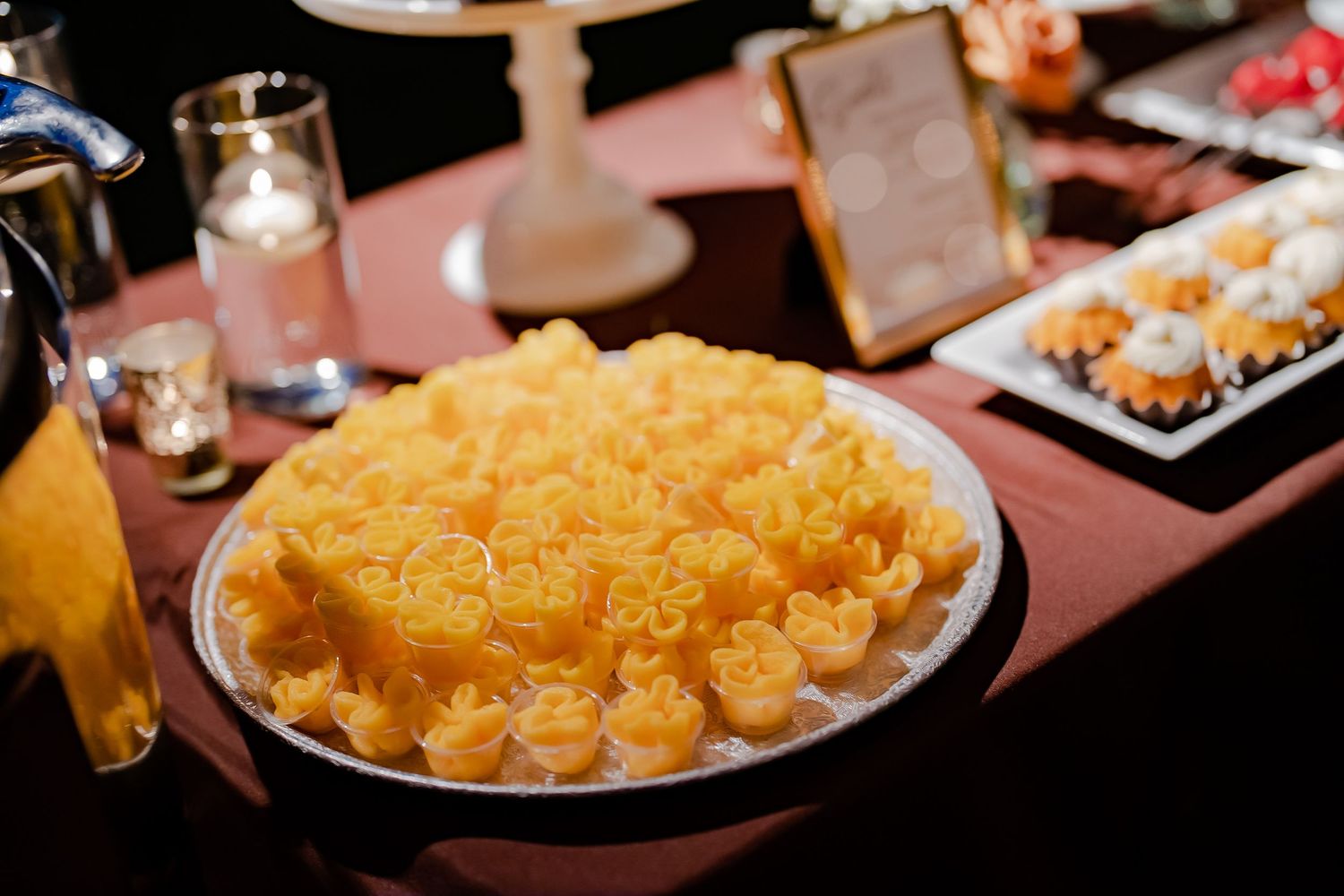 A platter of golden-brown macaroni and cheese bites arranged for a wedding reception.