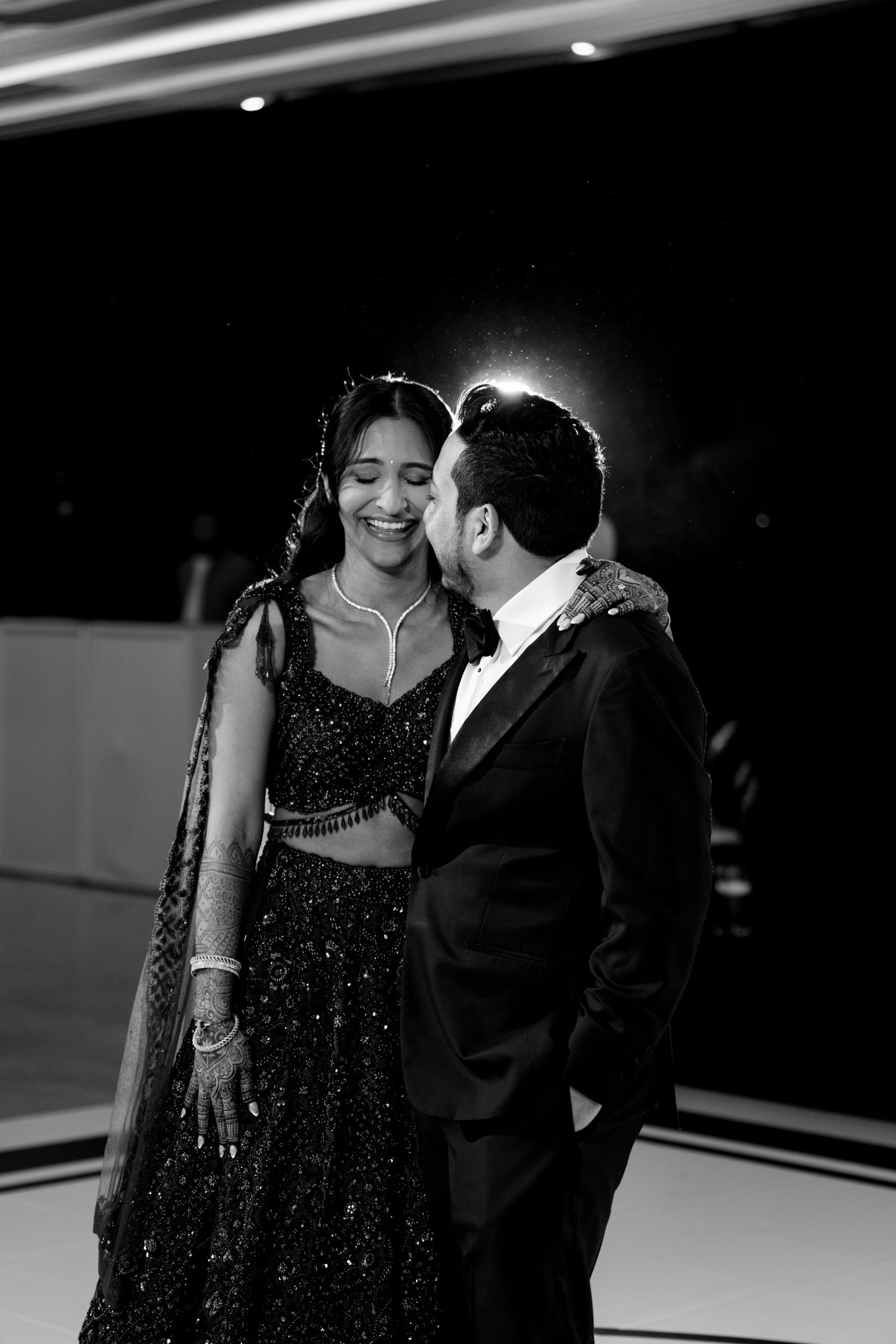 Romantic couple in formal attire sharing intimate moments in black and white photography.