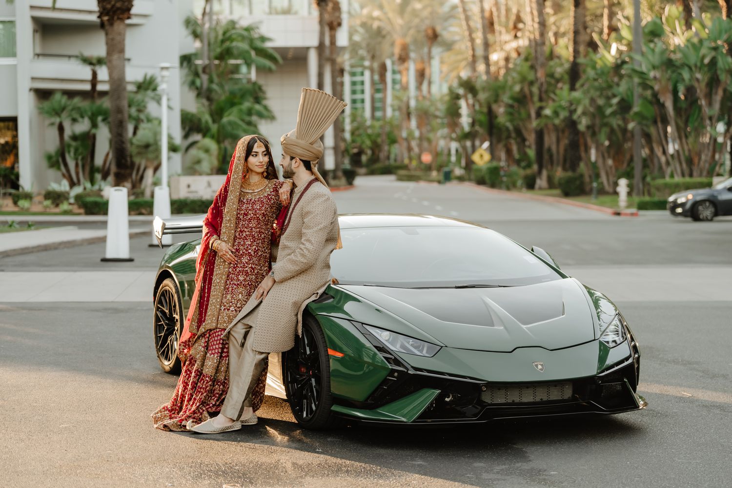 A sleek silver Lamborghini Aventador parked on a street with palm trees in the background.