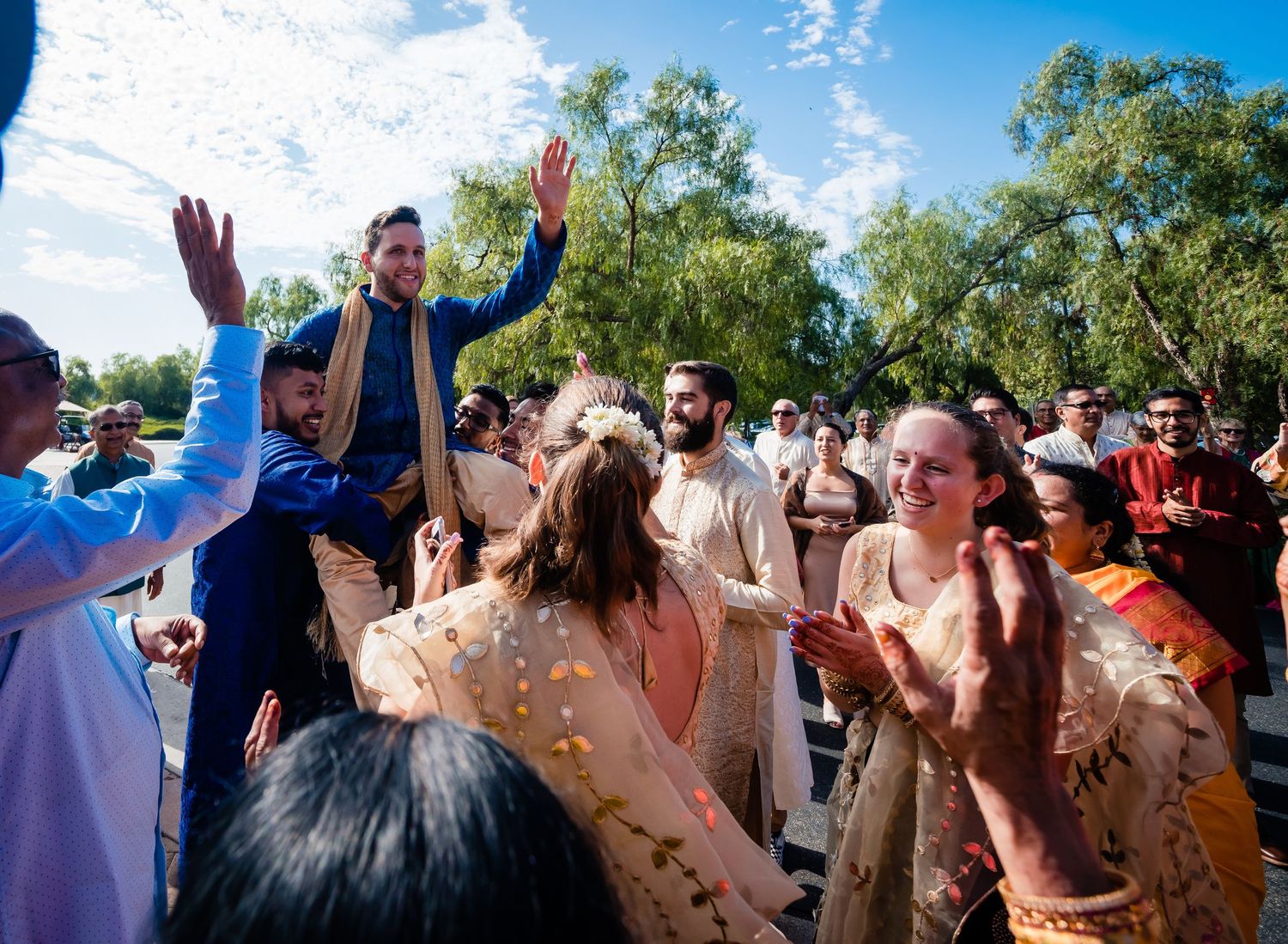 A group of people celebrating at an outdoor event by throwing colored powder in the air during a festival.