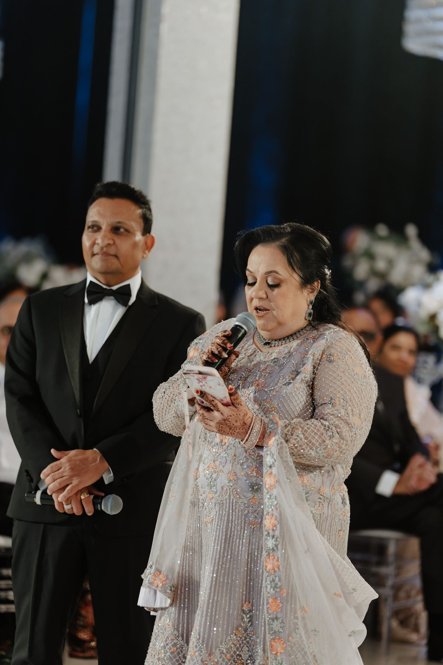 Couple performing a traditional dance in formal attire at an elegant reception.
