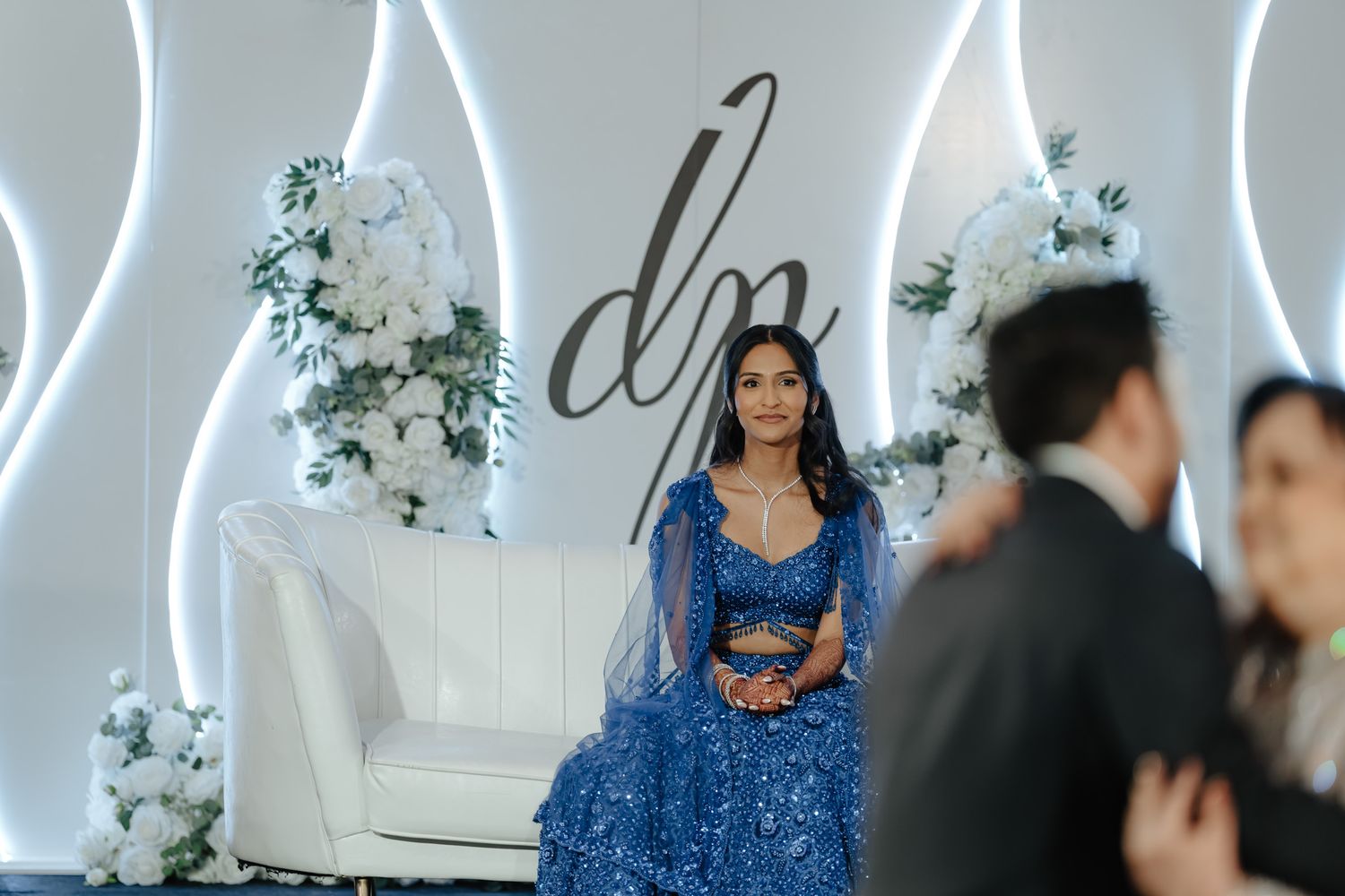 An elegant wedding reception setup with blue decor elements and modern white LED lighting features.