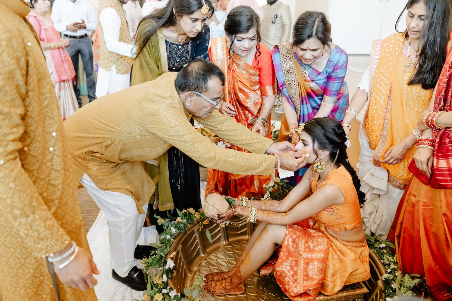 Traditional Indian wedding ceremony with guests gathered around for a ritual blessing.