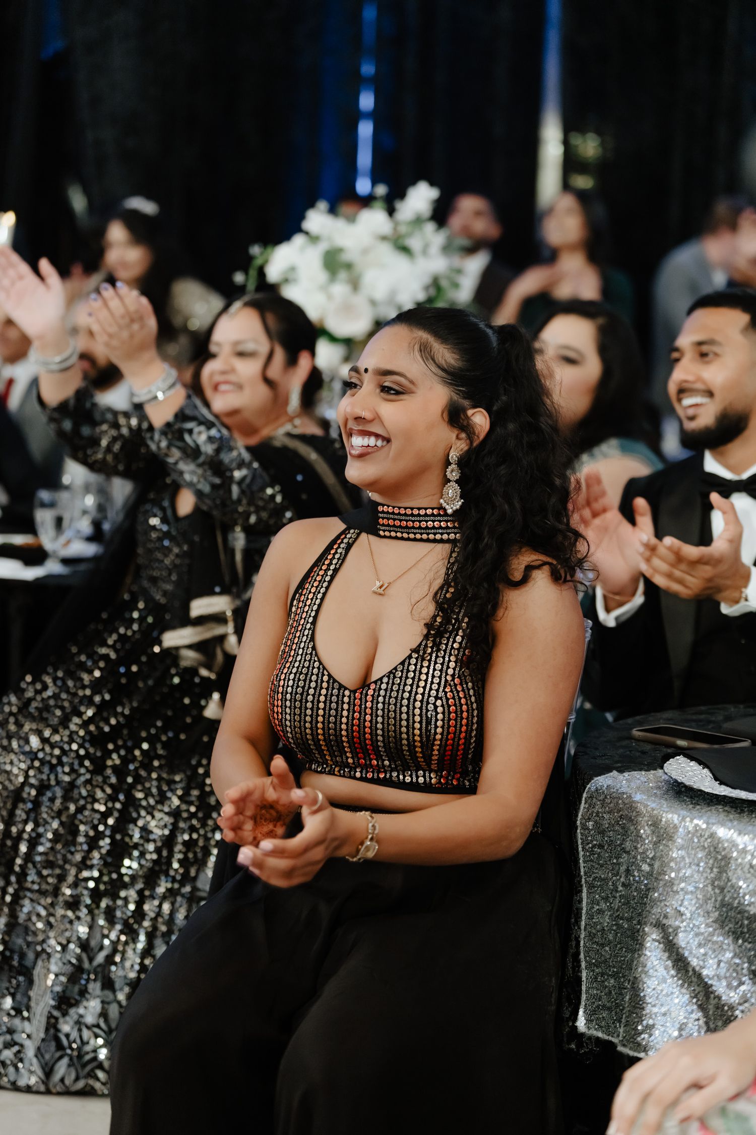 Reception guests enjoying entertainment in formal attire with sparkly decor.