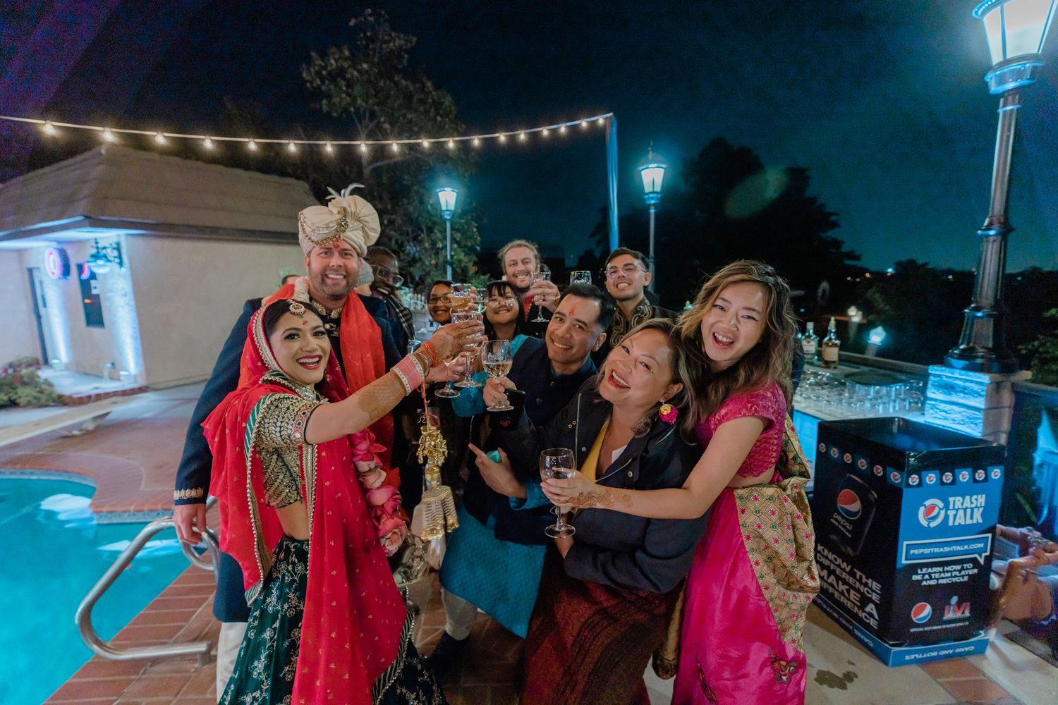 Outdoor nighttime gathering with string lights illuminating a crowd of people at a social event.