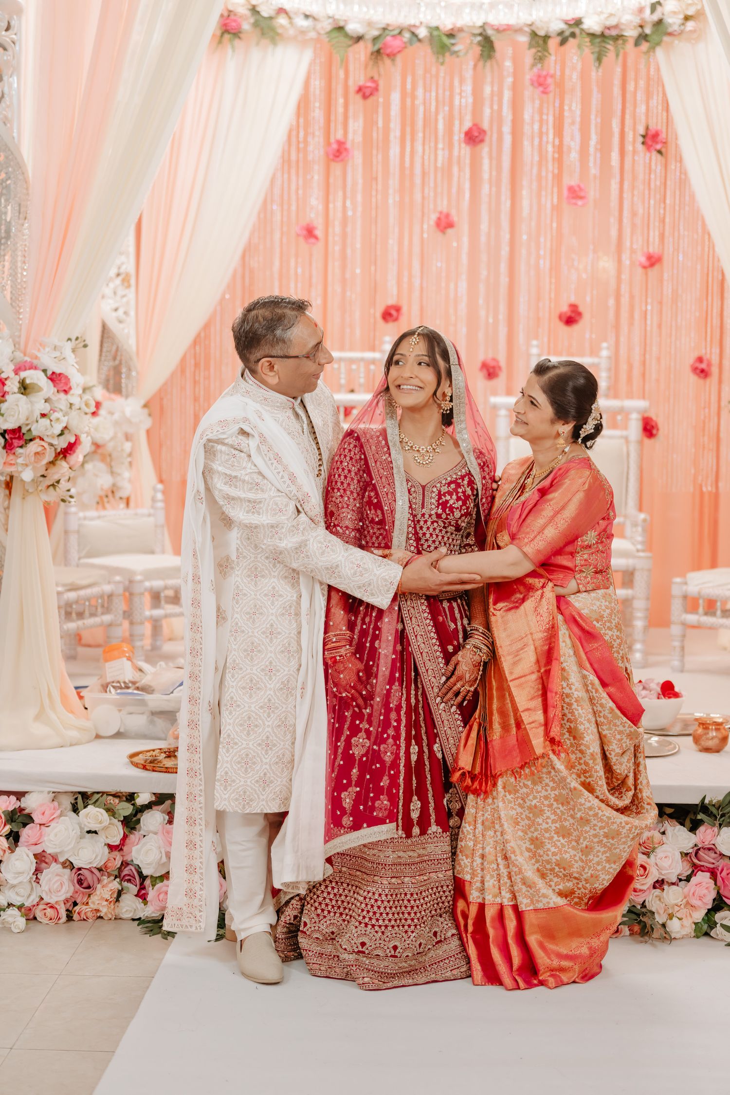 Wedding ceremony with pink and coral decor featuring traditional Indian customs and celebrations.