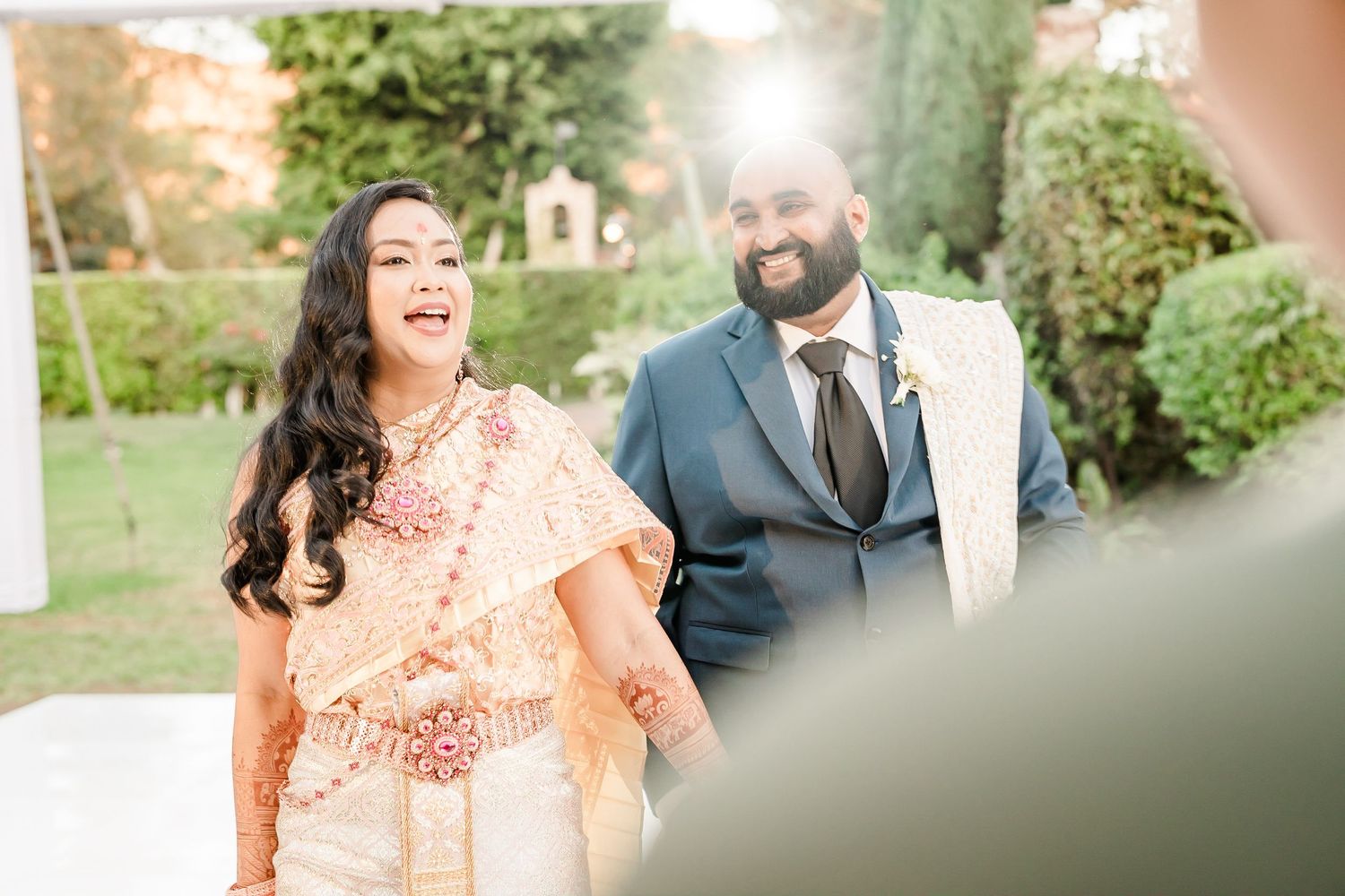 Joyful celebration at an outdoor garden wedding venue with soft natural lighting.