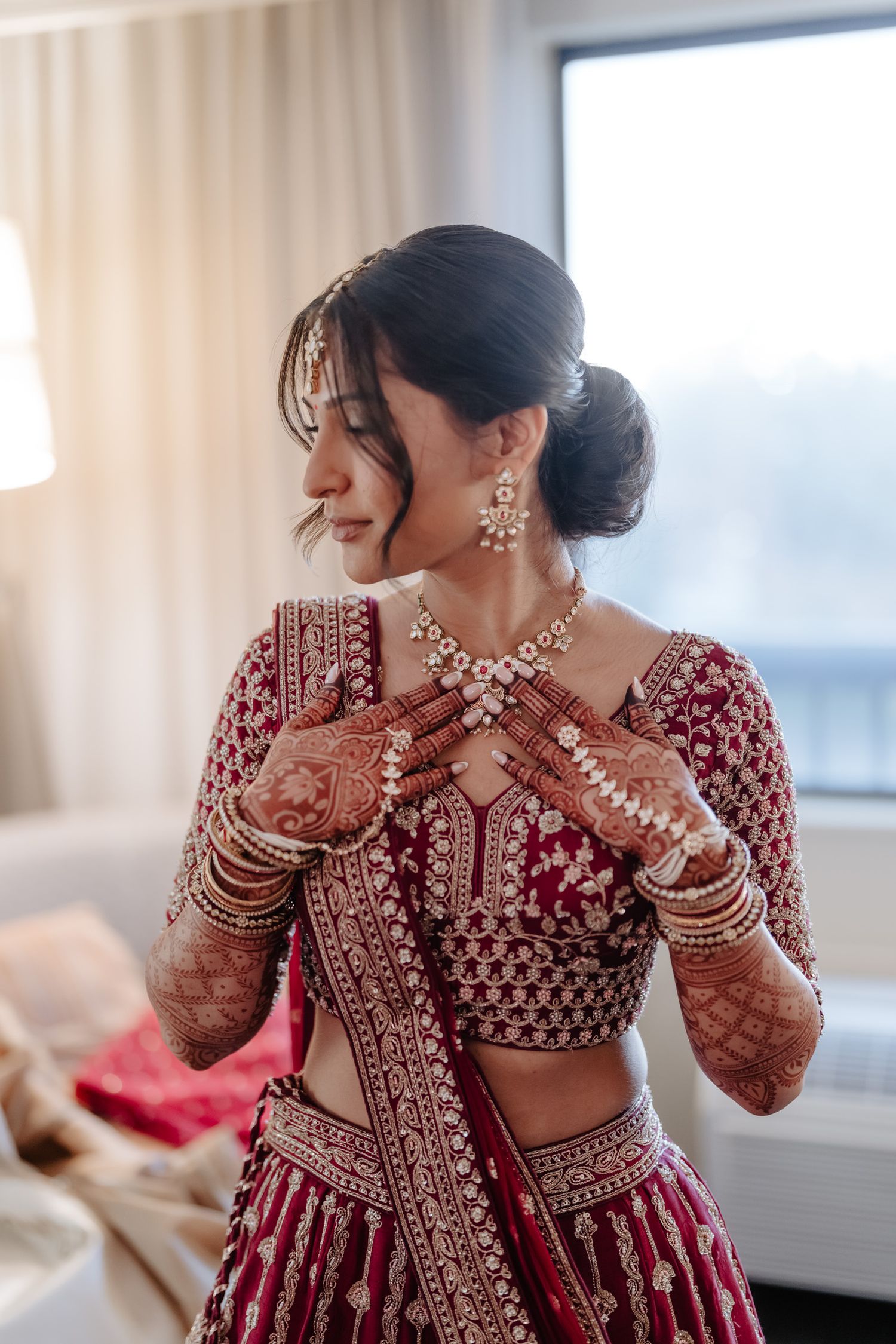 Artistic shots of bride in red lehenga showing intricate embroidery and traditional Indian bridal jewelry.